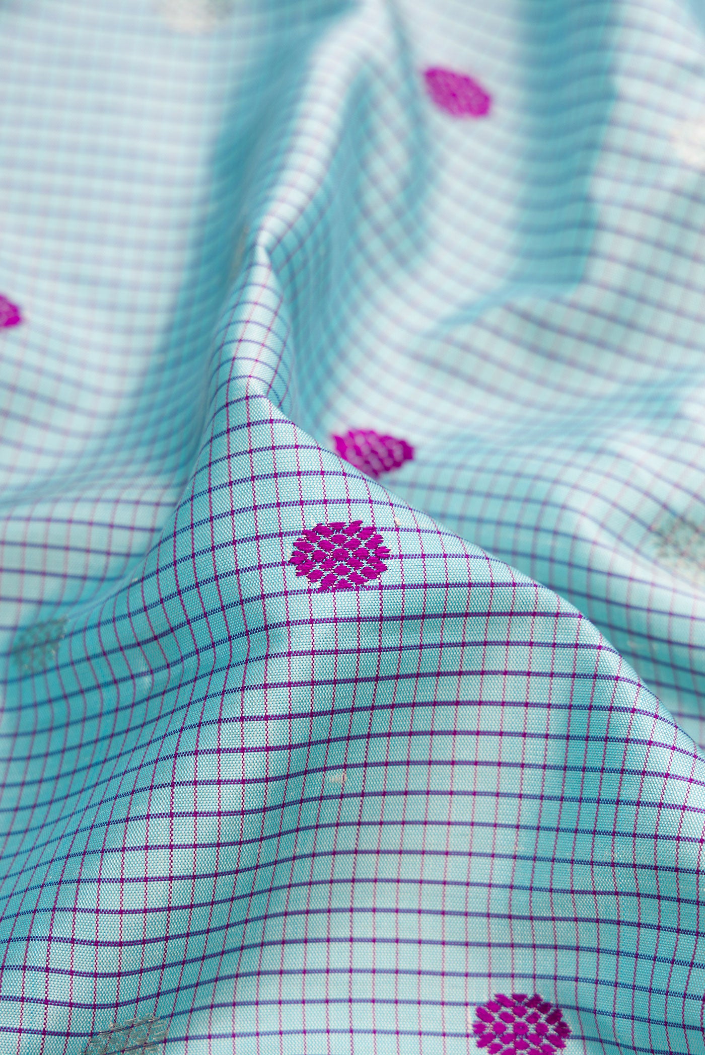 Close up of Sky Blue Gadwal Silk Saree with Checked design on the body and Temple Border.  displaying folds