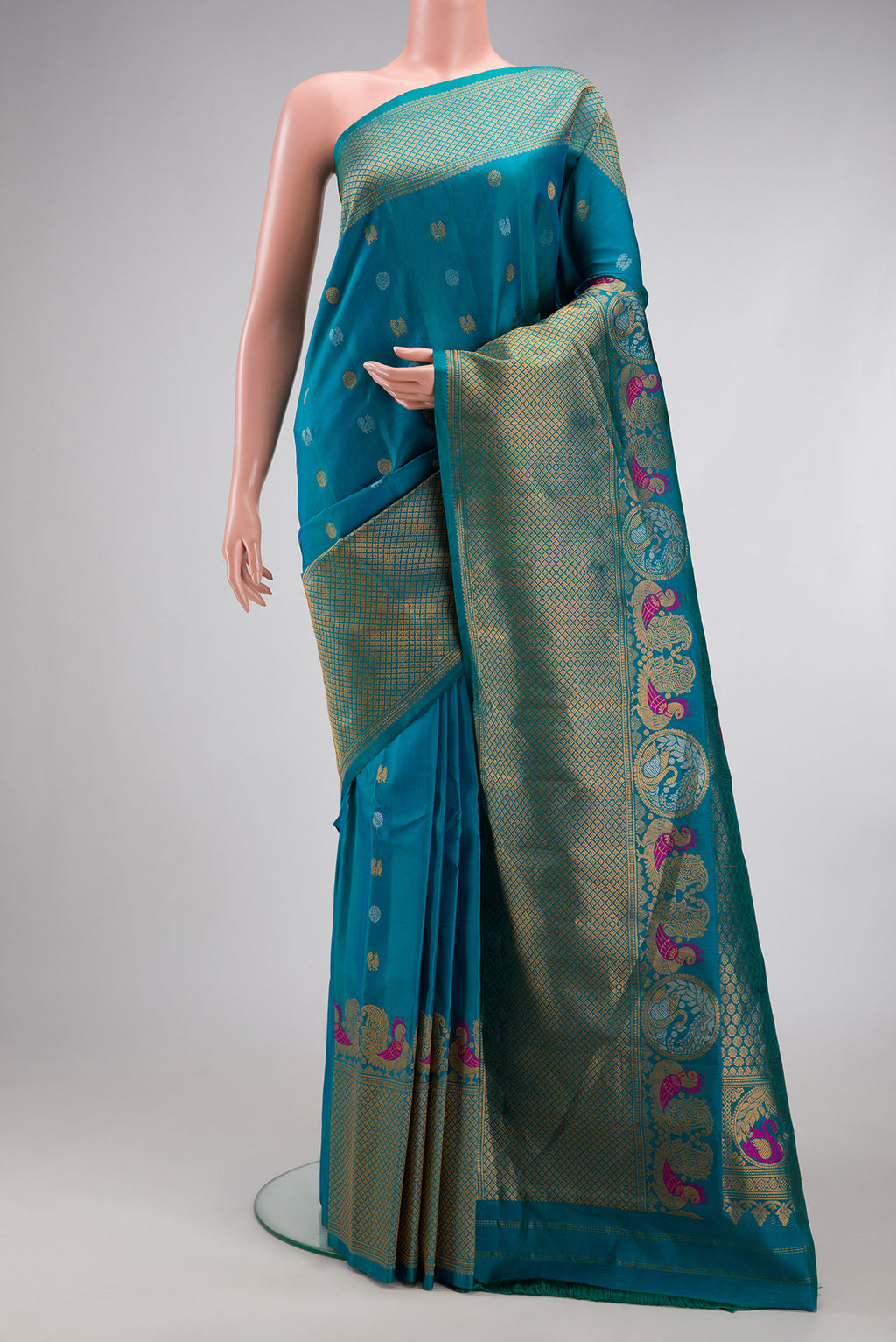 Peacock Blue Gadwal Silk Saree with Zari Butta on the body and Fancy Border.  displayed on a mannequin