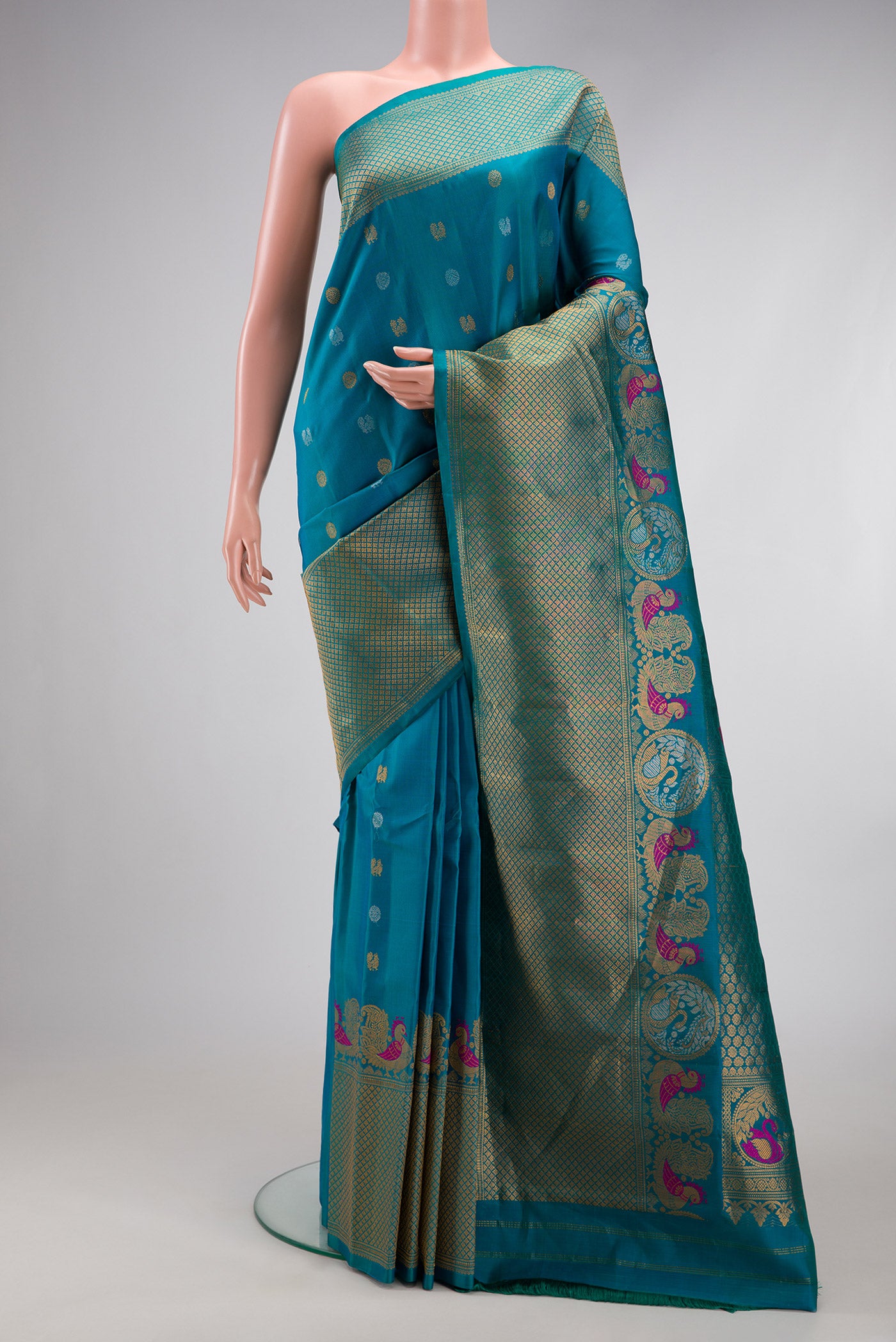 Peacock Blue Gadwal Silk Saree with Zari Butta on the body and Fancy Border.  displayed on a mannequin