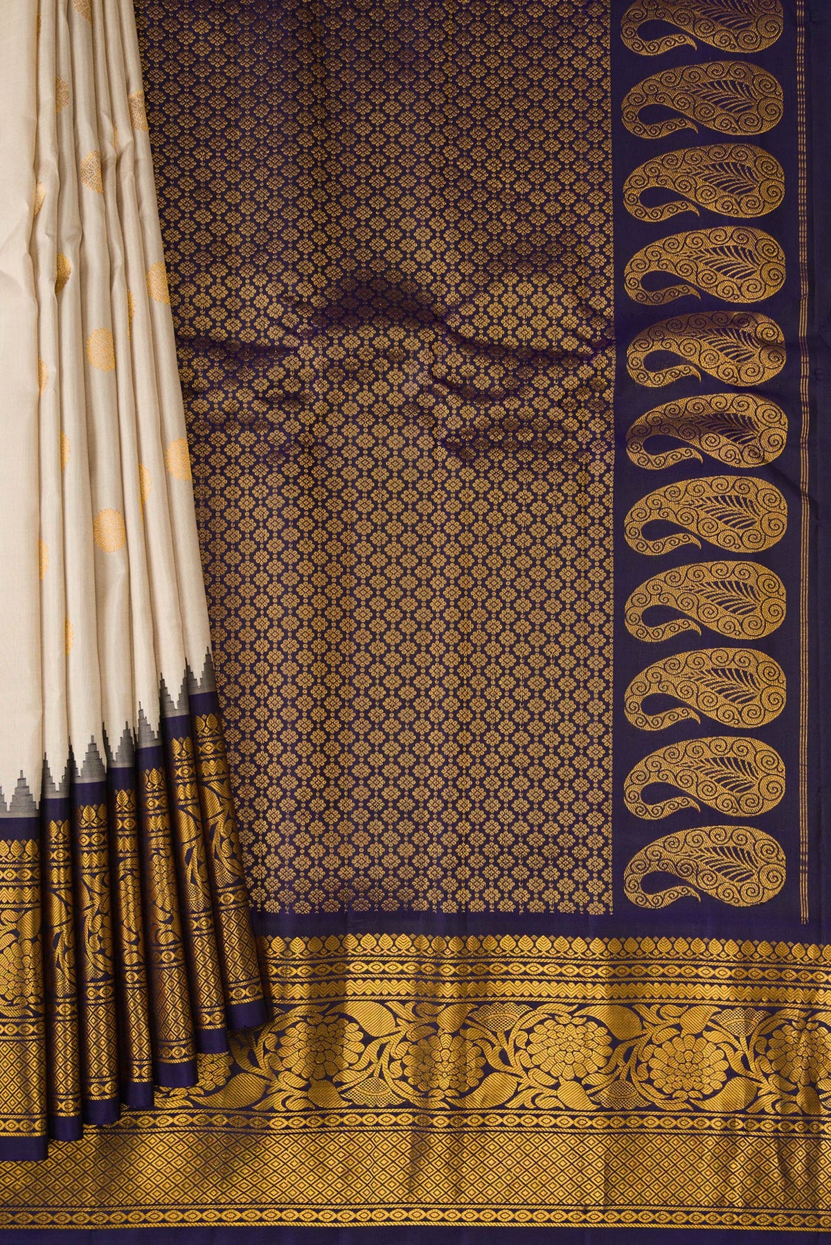 Pleats and pallu of Cream Gadwal Silk Saree with Zari Butta on the body and Zari Border. 