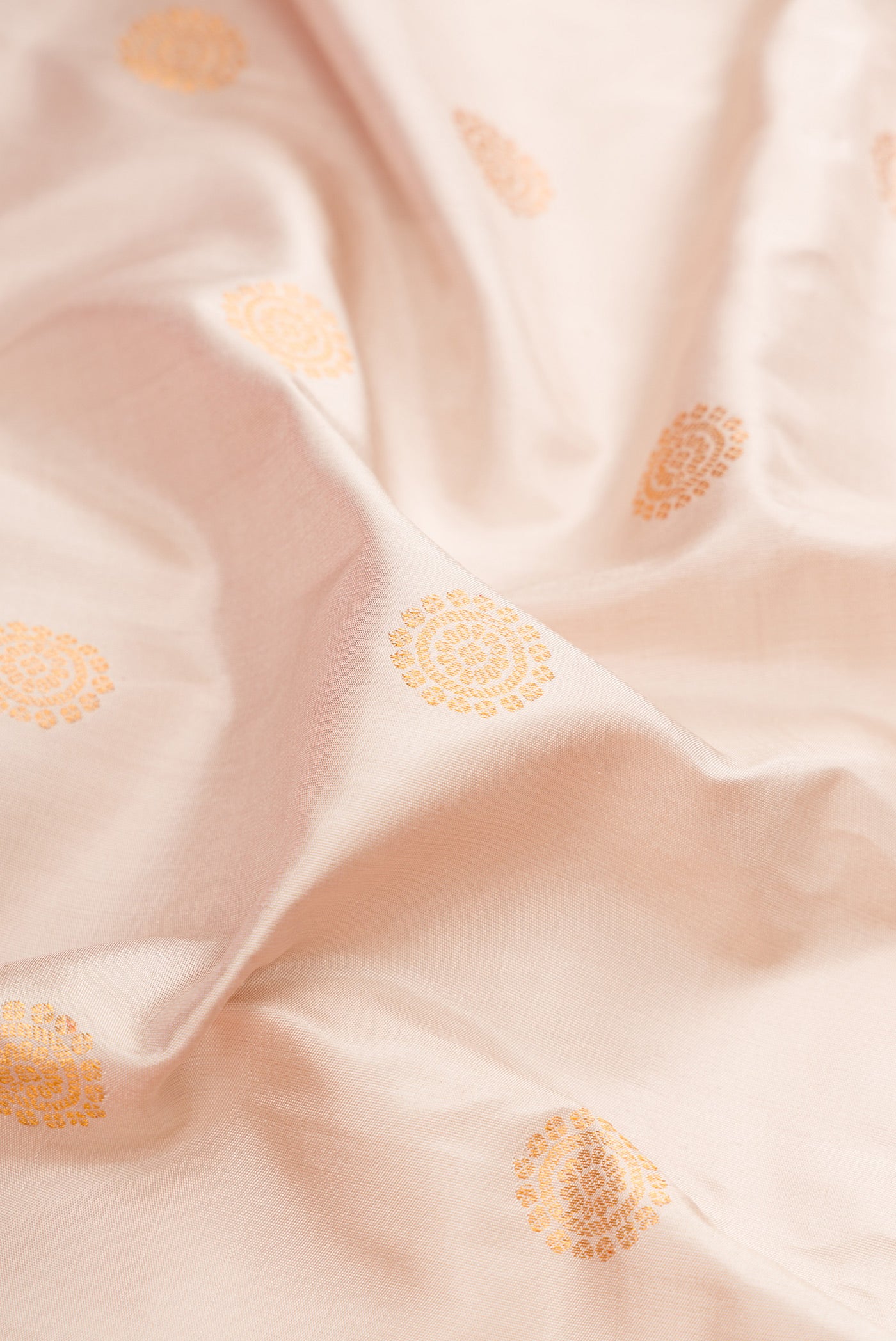 Close up of Cream Gadwal Silk Saree with Zari Butta on the body and Zari Border.  displaying folds