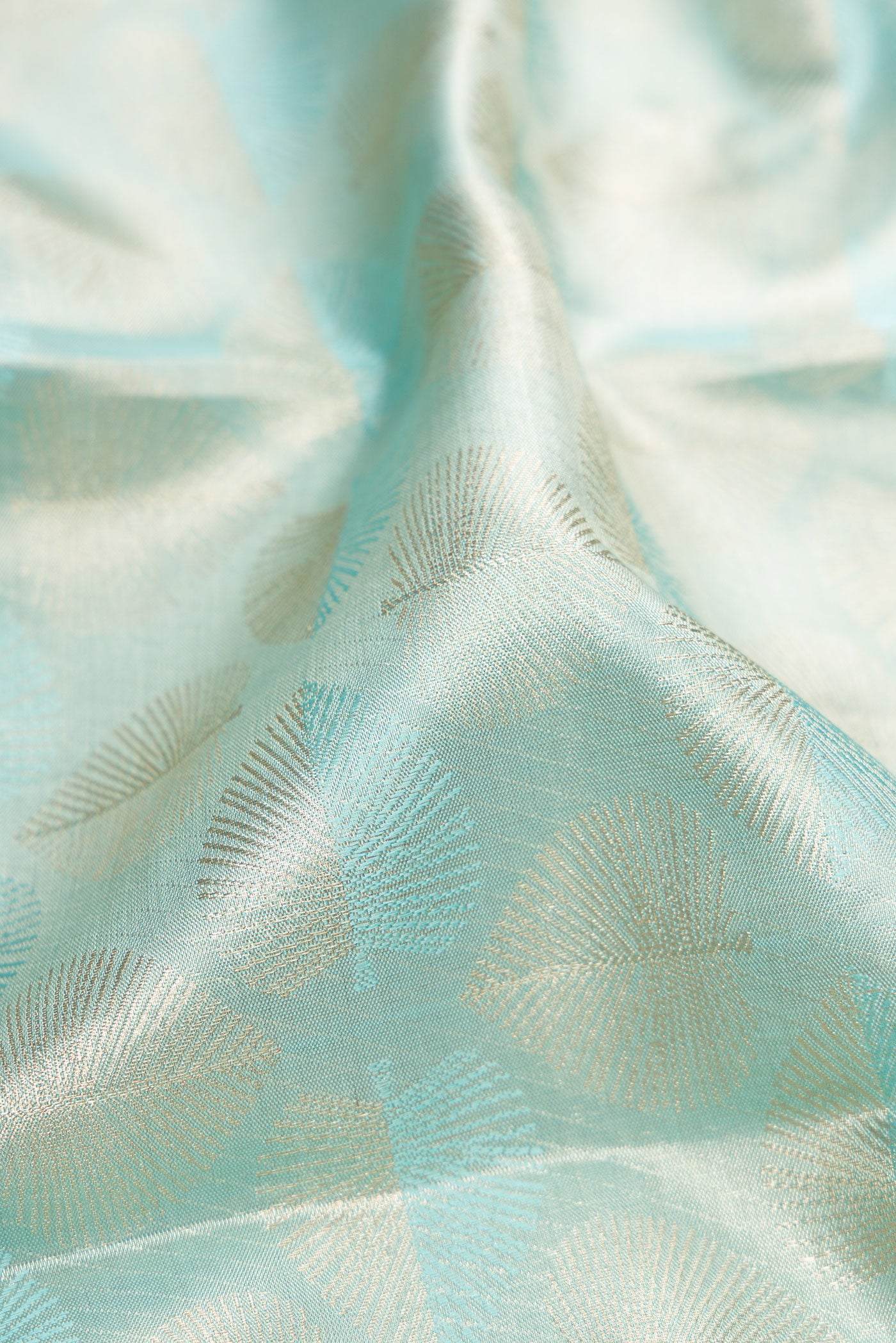 Close up of Sky Blue Dual Tone Kanjivaram Tissue Silk Saree with Zari Brocade on the body and Zari Border.  displaying folds