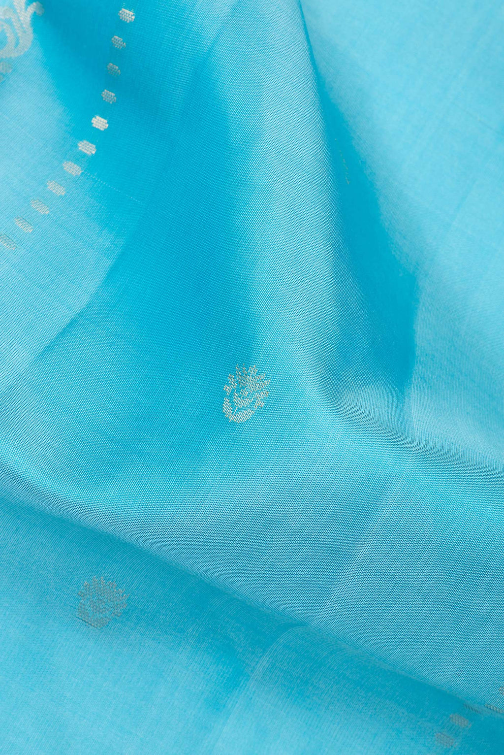 Close up of Pure Silk Sky Blue Dual Tone Soft Saree with Zari Butta on the body and Zari Border.  displaying folds