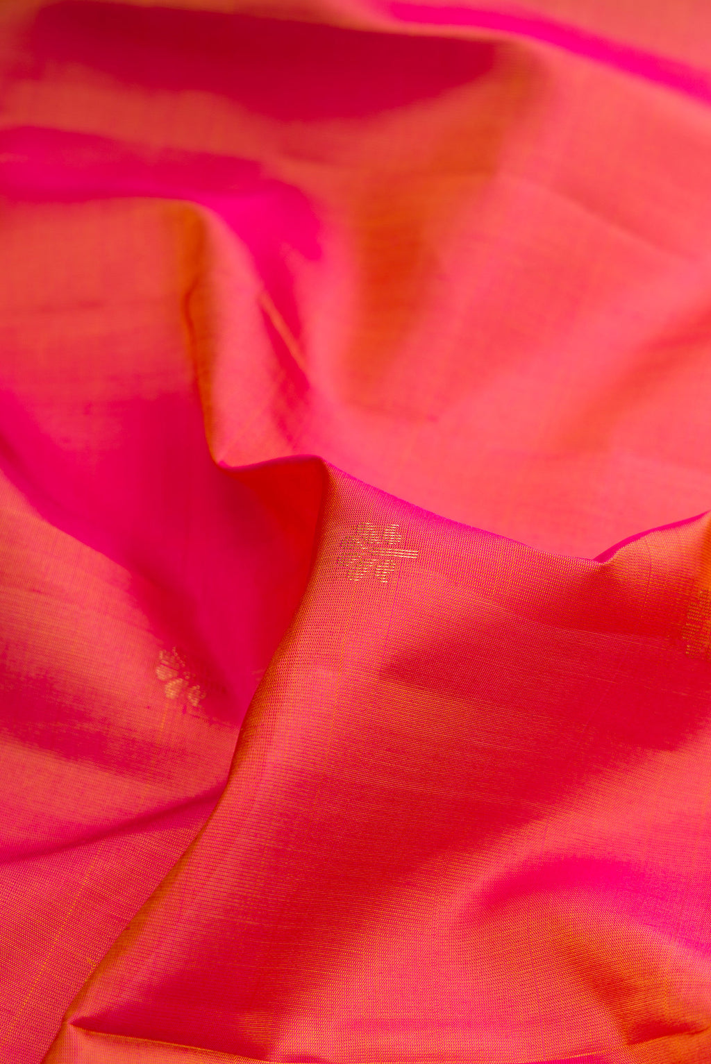 Close up of Coral Dual Tone Soft Silk Saree with Zari Butta on the body and Fancy Border.  displaying folds