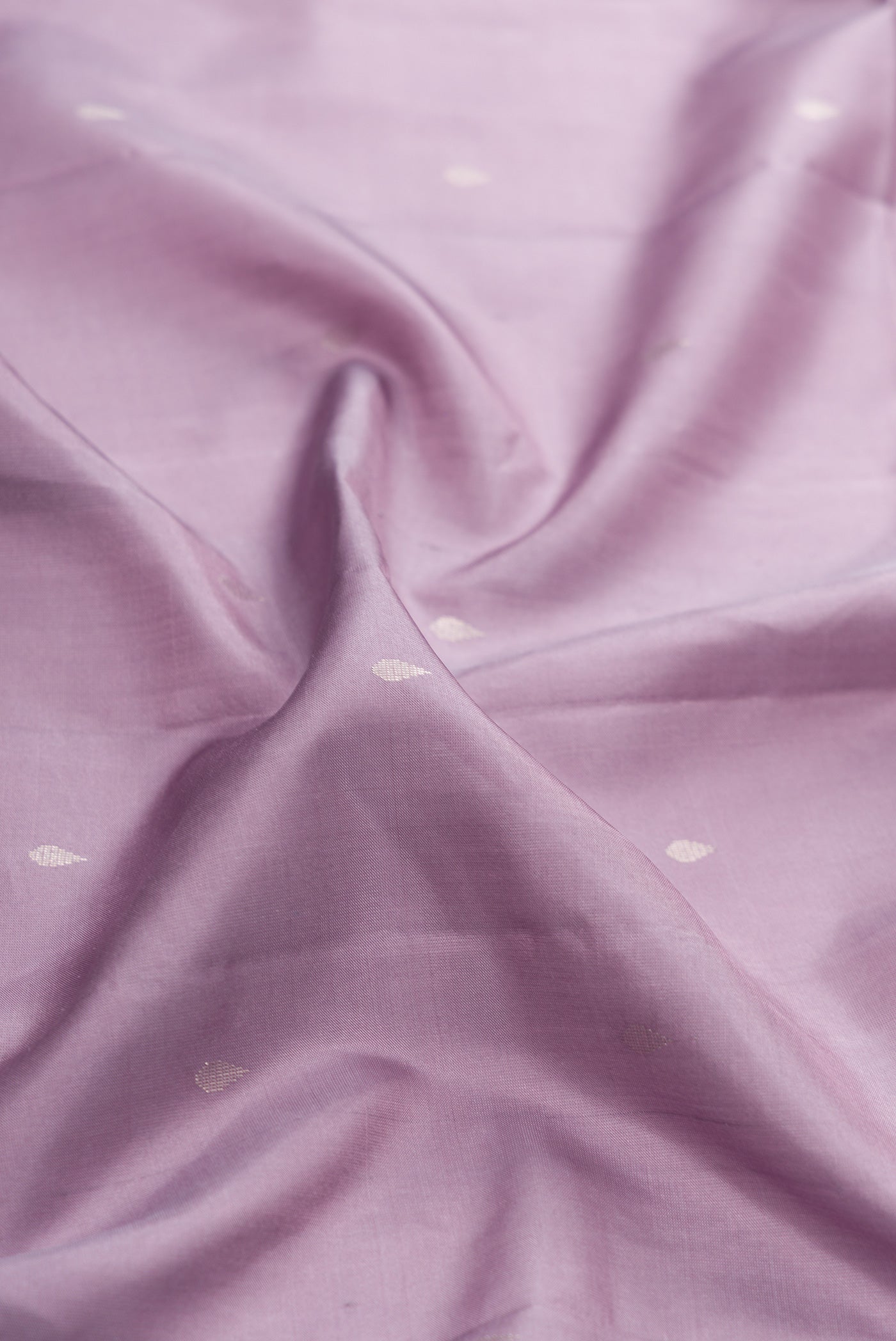 Close up of Lavender Soft Silk Saree with Zari Butta on the body and Fancy Border.  displaying folds