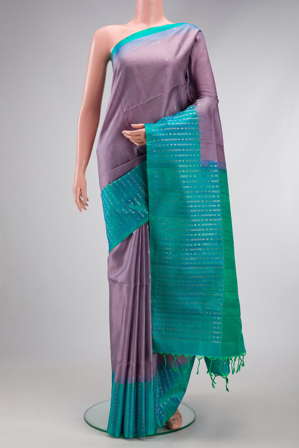 Lavender Soft Silk Saree with Zari Butta on the body and Fancy Border.  displayed on a mannequin
