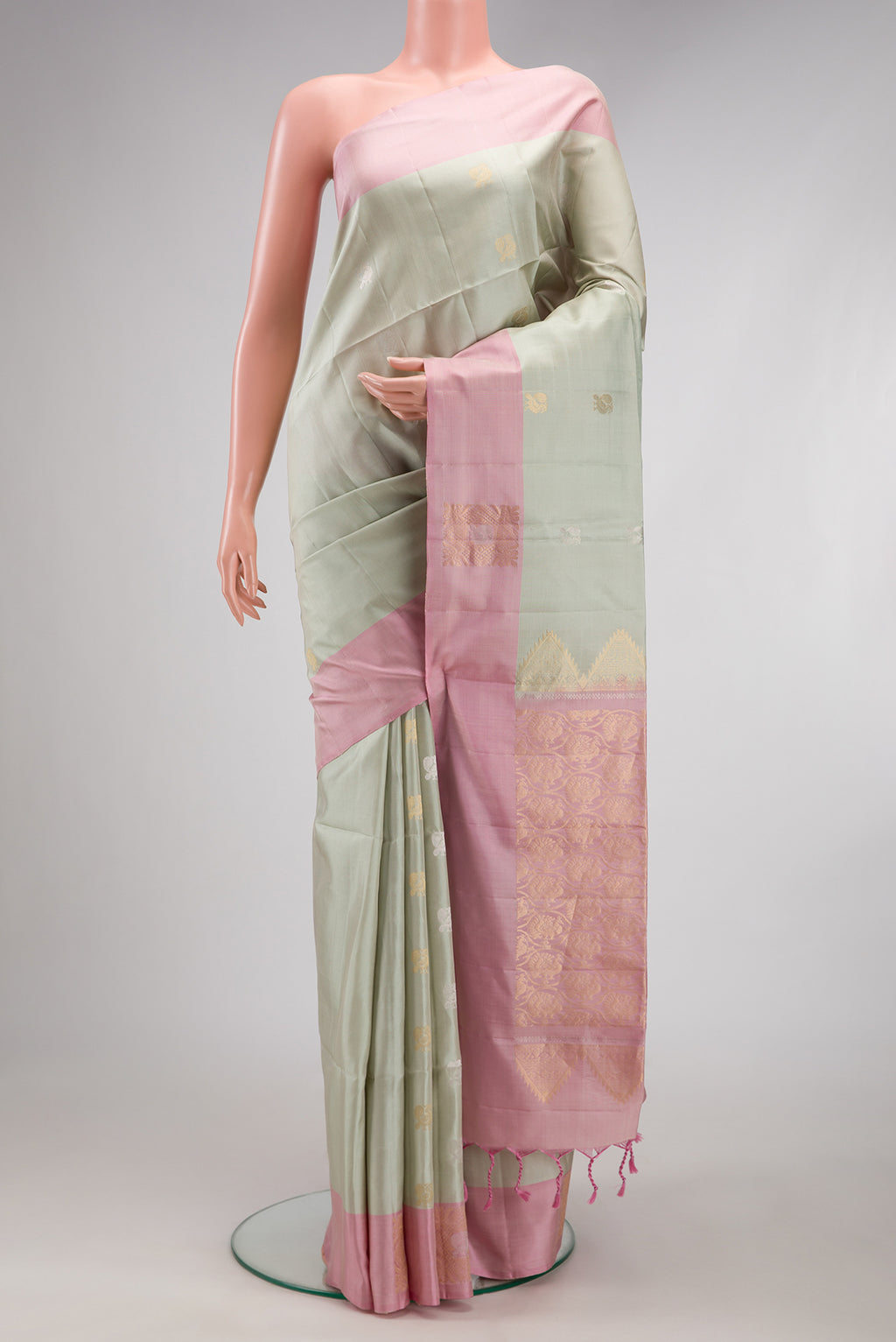 Light Green Soft Silk Saree with Zari Butta on the body and Fancy Border.  displayed on a mannequin