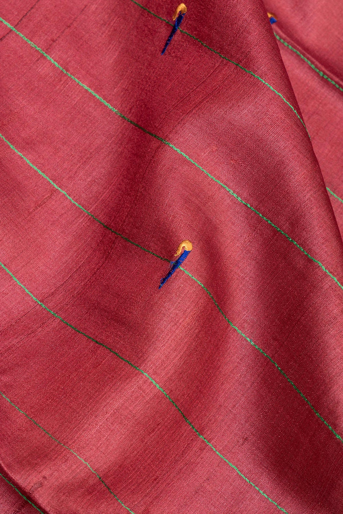 Close up of Pure Silk Rust Tussar Saree with Embroidered on the body and Zari Border.  displaying folds