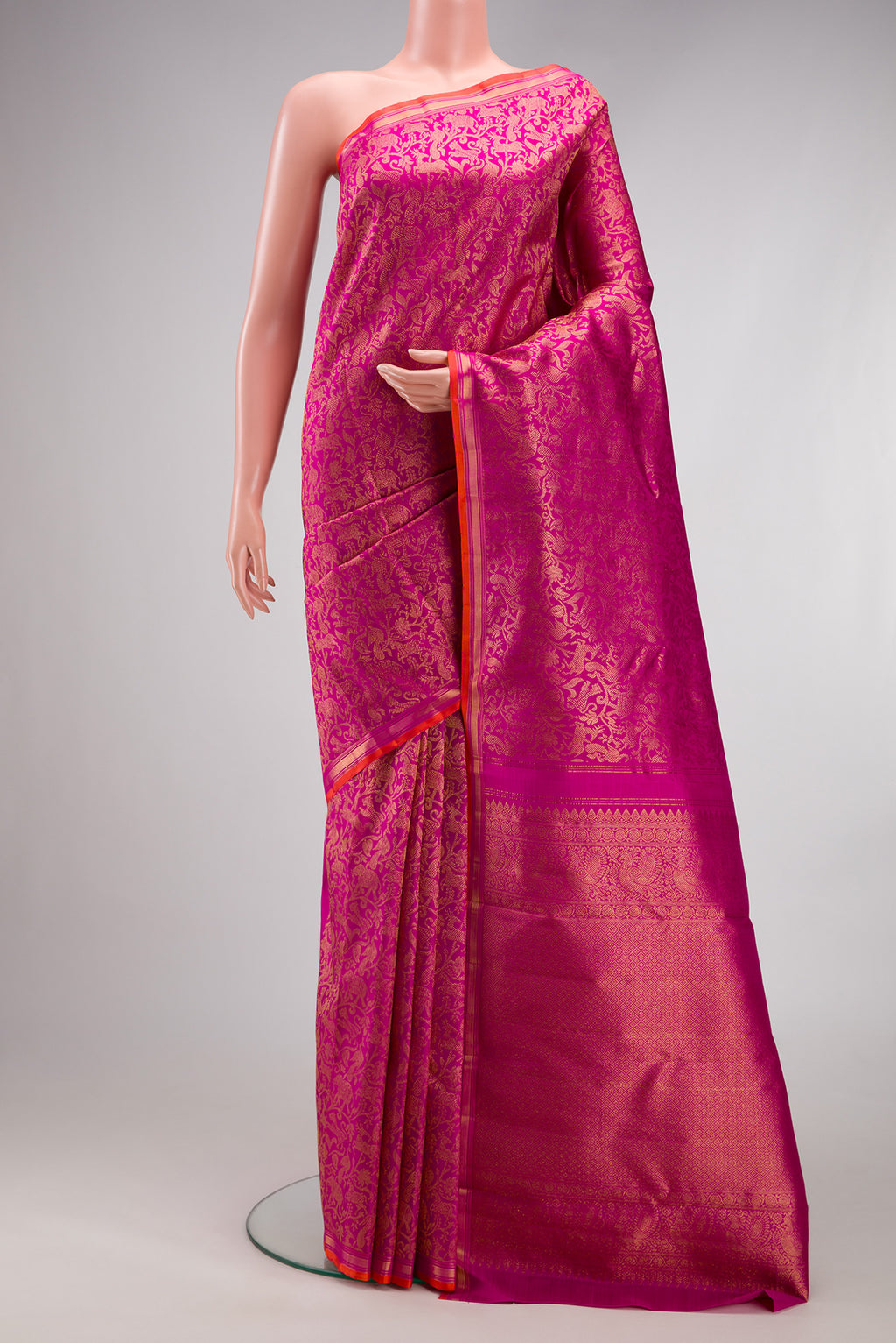 Magenta Kanjivaram Silk Saree with Zari Brocade on the body and Zari Border.  displayed on a mannequin