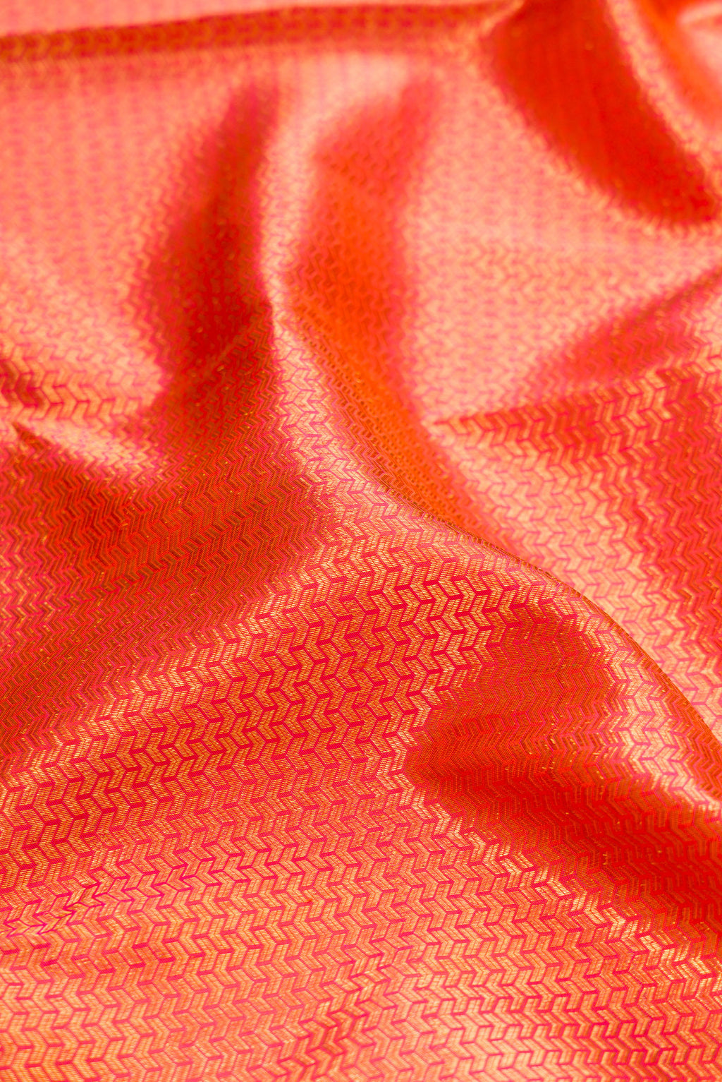 Close up of Orange Dual Tone Kanchipuram Silk Saree with Zari Brocade on the body and Zari Border.  displaying folds