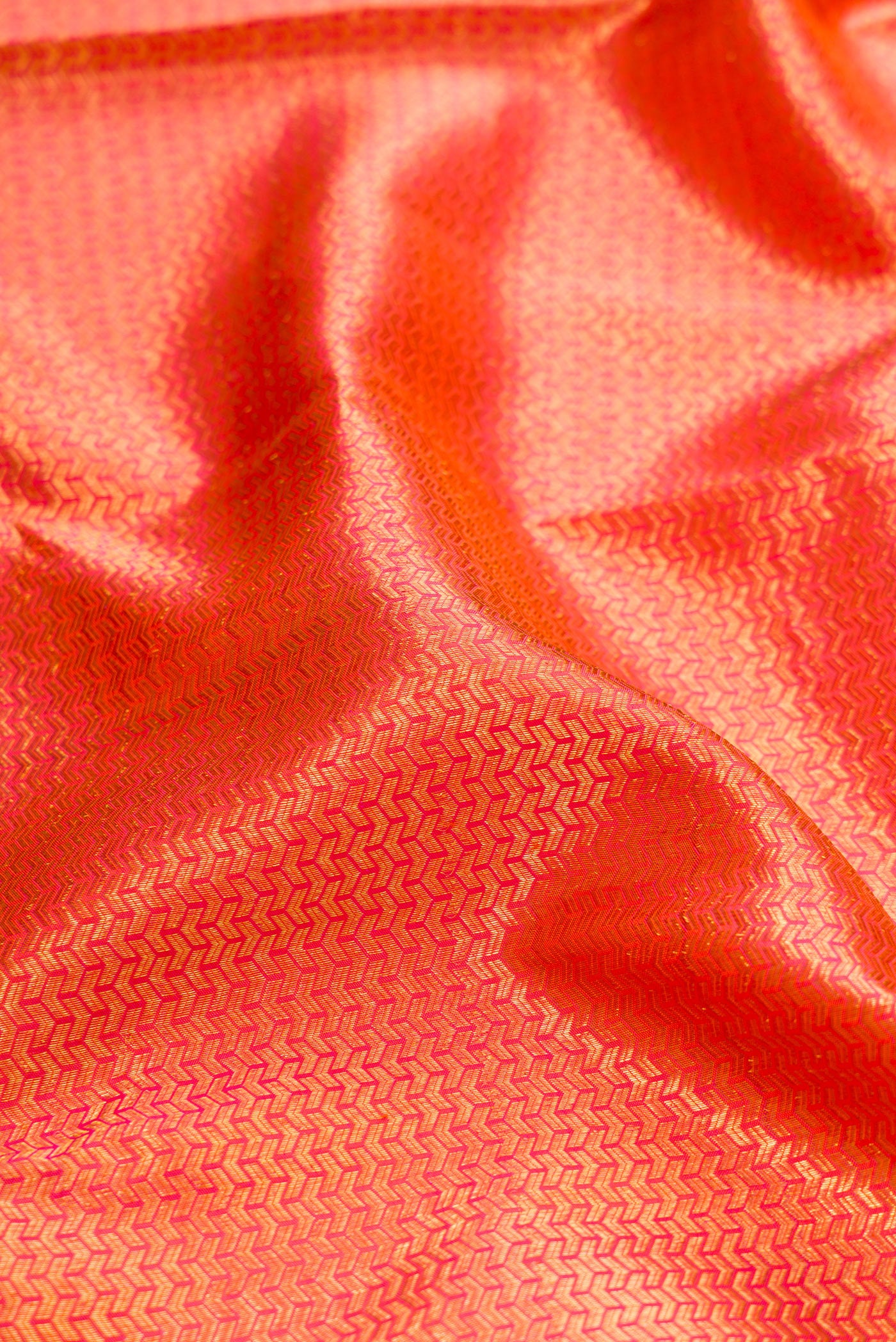 Close up of Orange Dual Tone Kanchipuram Silk Saree with Zari Brocade on the body and Zari Border.  displaying folds