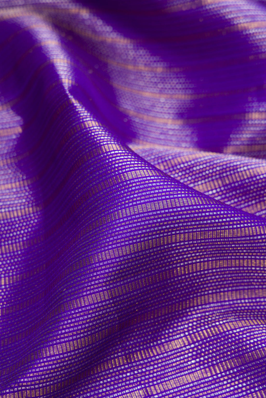 Close up of Violet Kanchipuram Silk Saree with Zari Brocade on the body and Zari Border.  displaying folds
