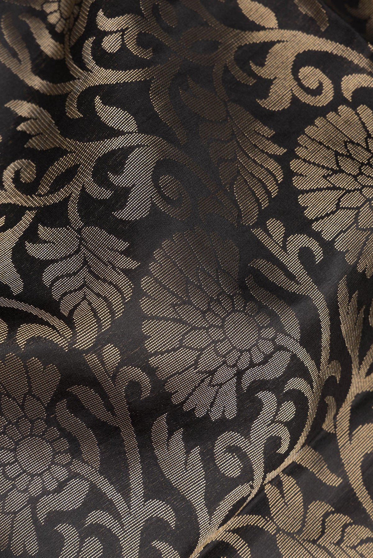 Close up of Pure Silk Black Dual Tone Soft Saree with Zari Brocade on the body and Fancy Border.  displaying folds