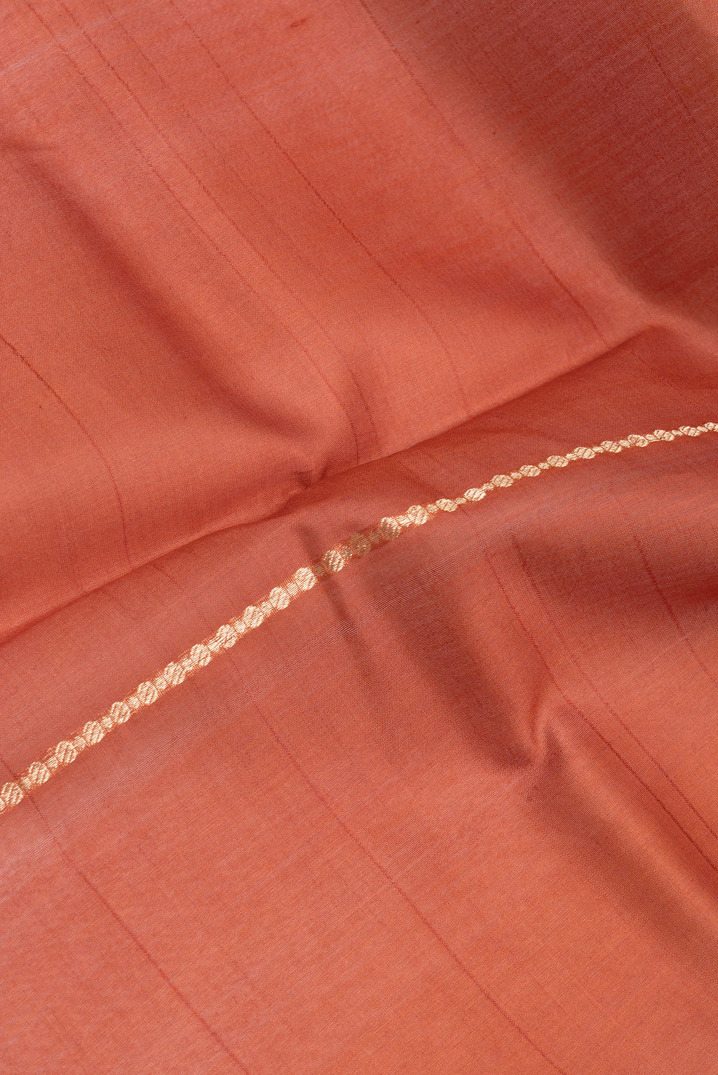 Close up of Rust Dual Tone Organza Silk Saree with Stripes on the body and Zari Border.  displaying folds