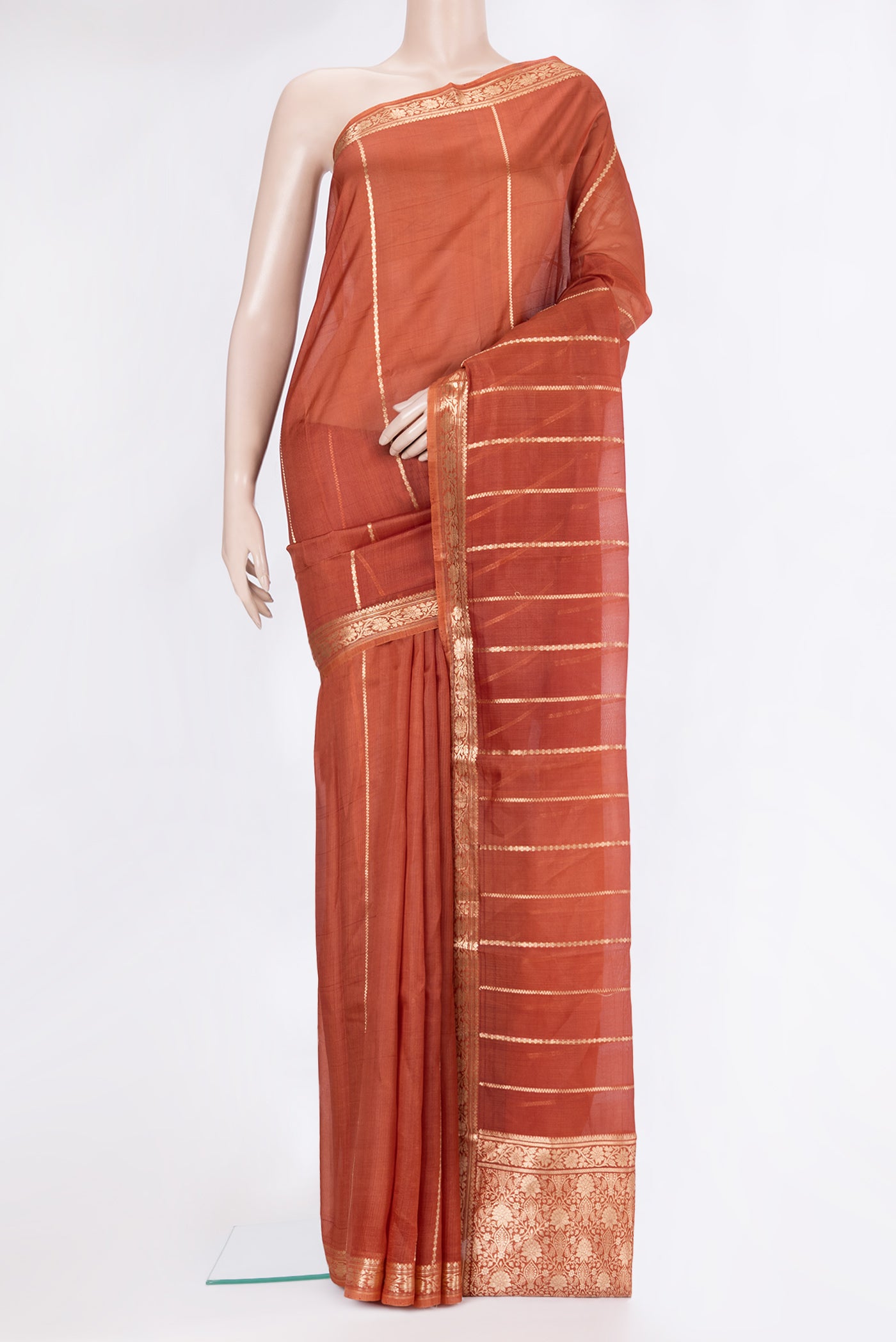 Rust Dual Tone Organza Silk Saree with Stripes on the body and Zari Border.  displayed on a mannequin