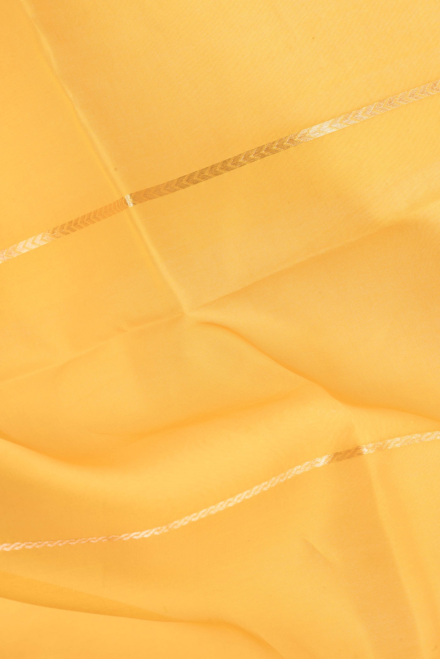 Close up of Yellow Organza Silk Saree with Stripes on the body and Zari Border.  displaying folds
