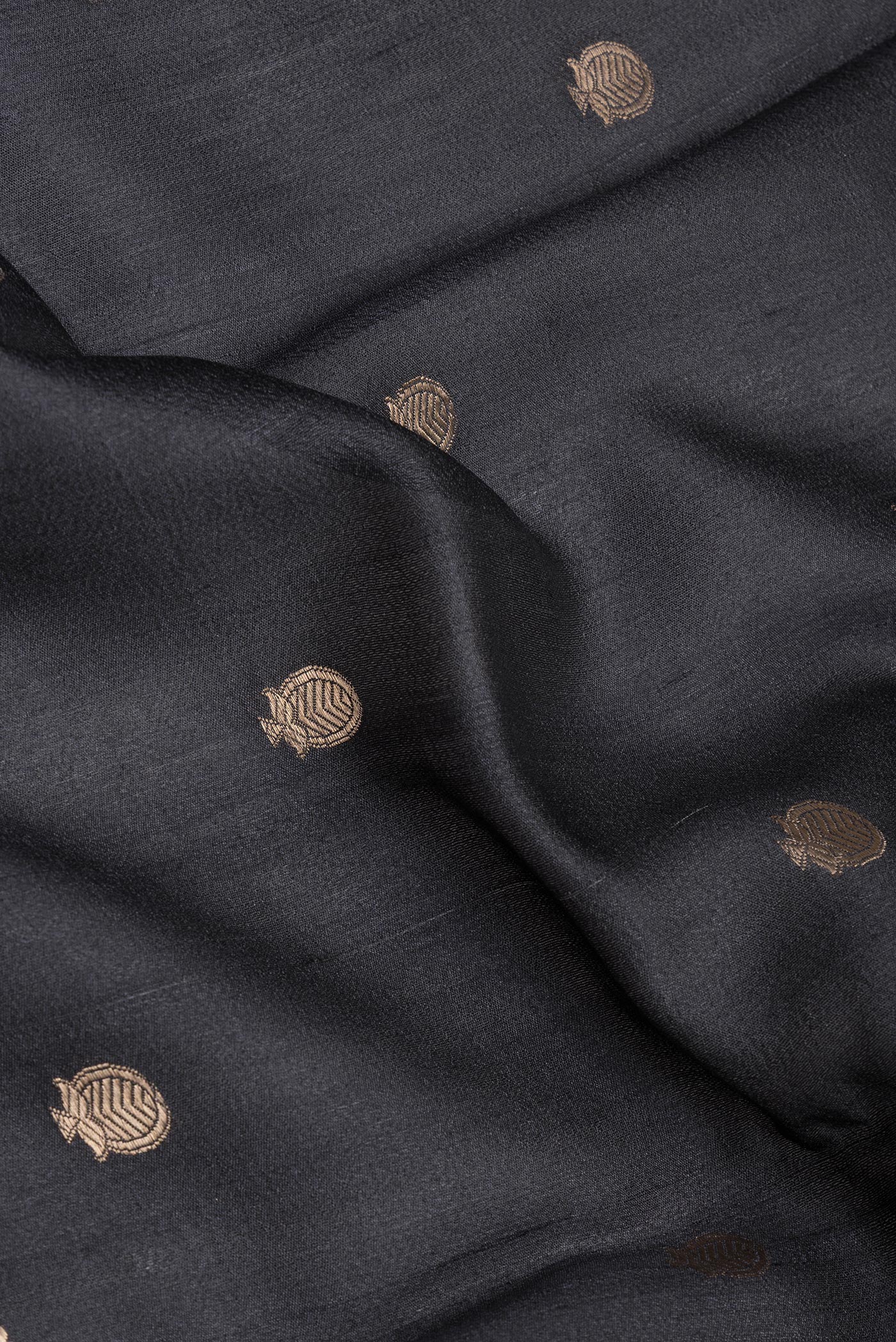 Close up of Black Tussar Silk Saree with Zari Butta on the body and Fancy Border.  displaying folds