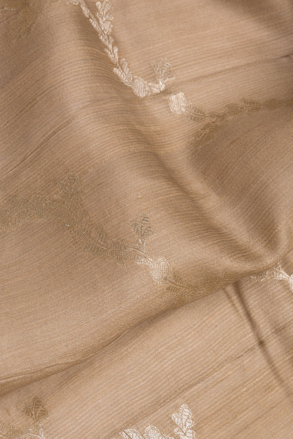 Close up of Dark Beige Tussar Silk Saree with Zari Brocade on the body and Fancy Border.  displaying folds