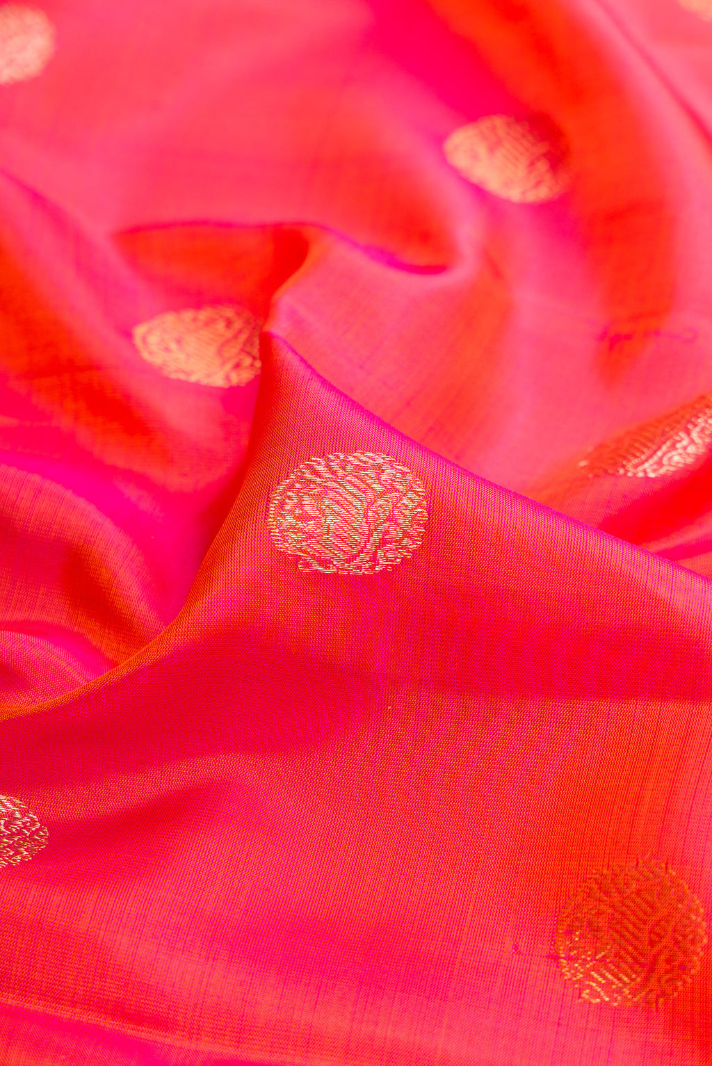 Close up of Pink with Orange Color Kanjivaram Silk Saree with Zari Butta on the body and Fancy Border.  displaying folds