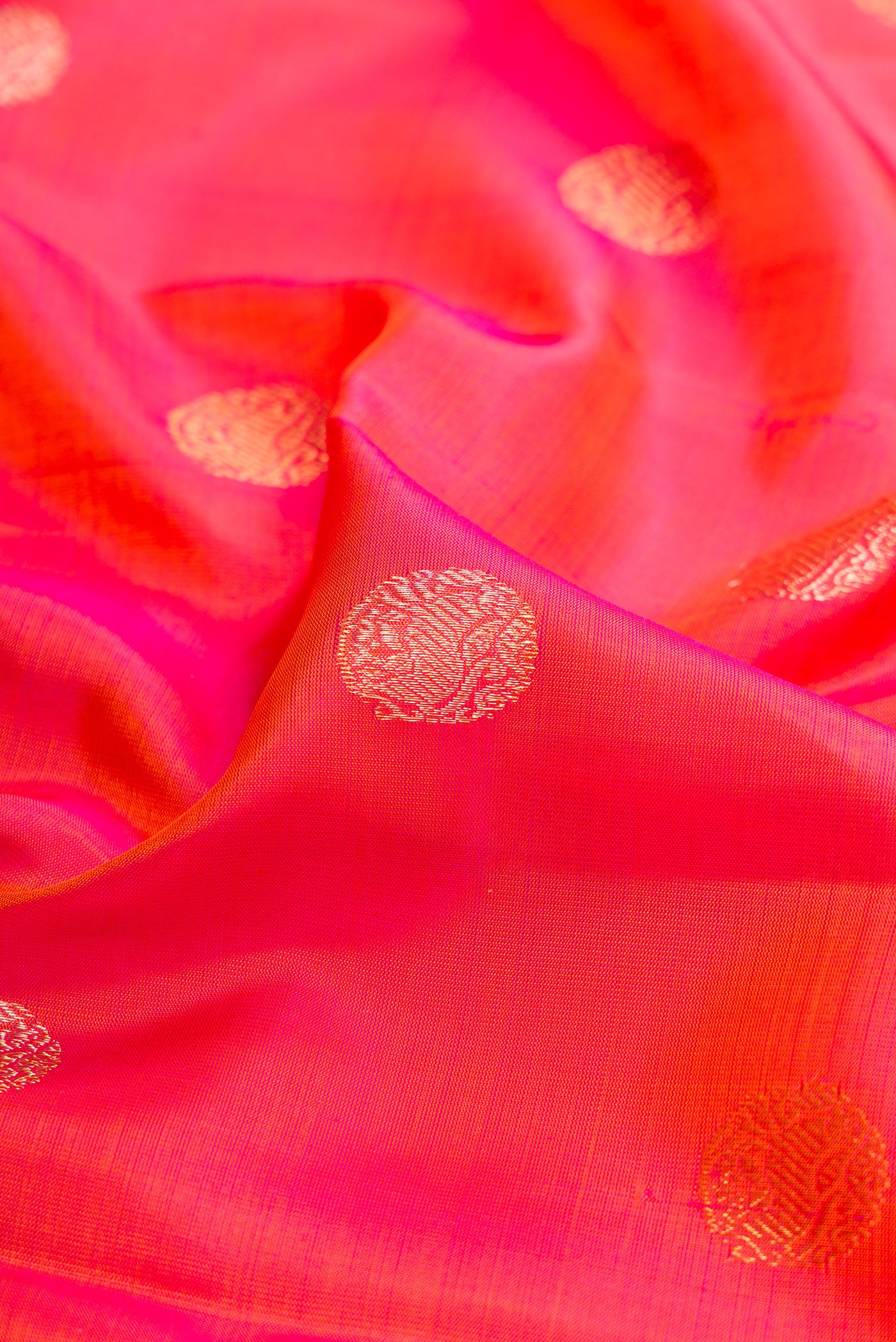Close up of Pink with Orange Color Kanjivaram Silk Saree with Zari Butta on the body and Fancy Border.  displaying folds