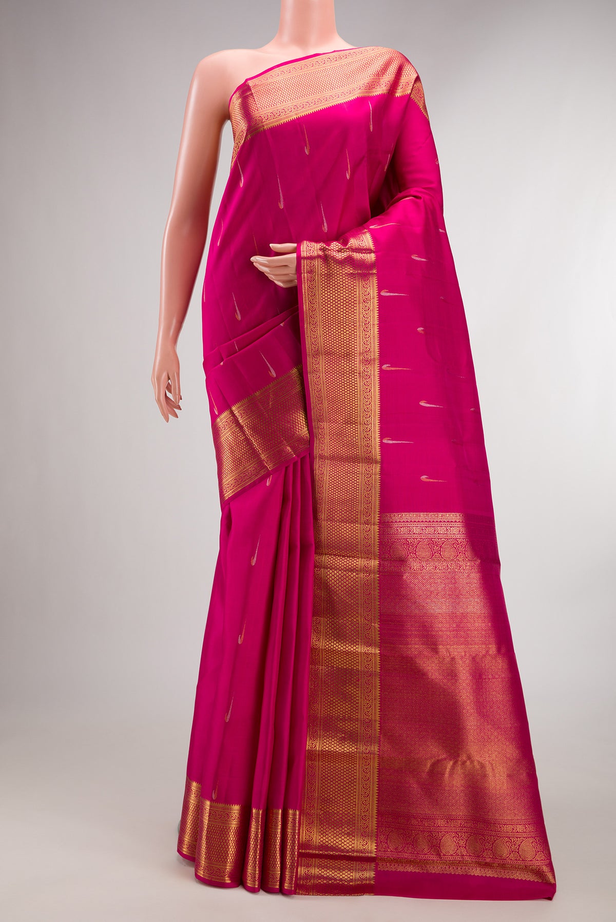 Pure Silk Rani Pink Kanchipuram Saree with Zari Butta on the body and Zari Border.  displayed on a mannequin