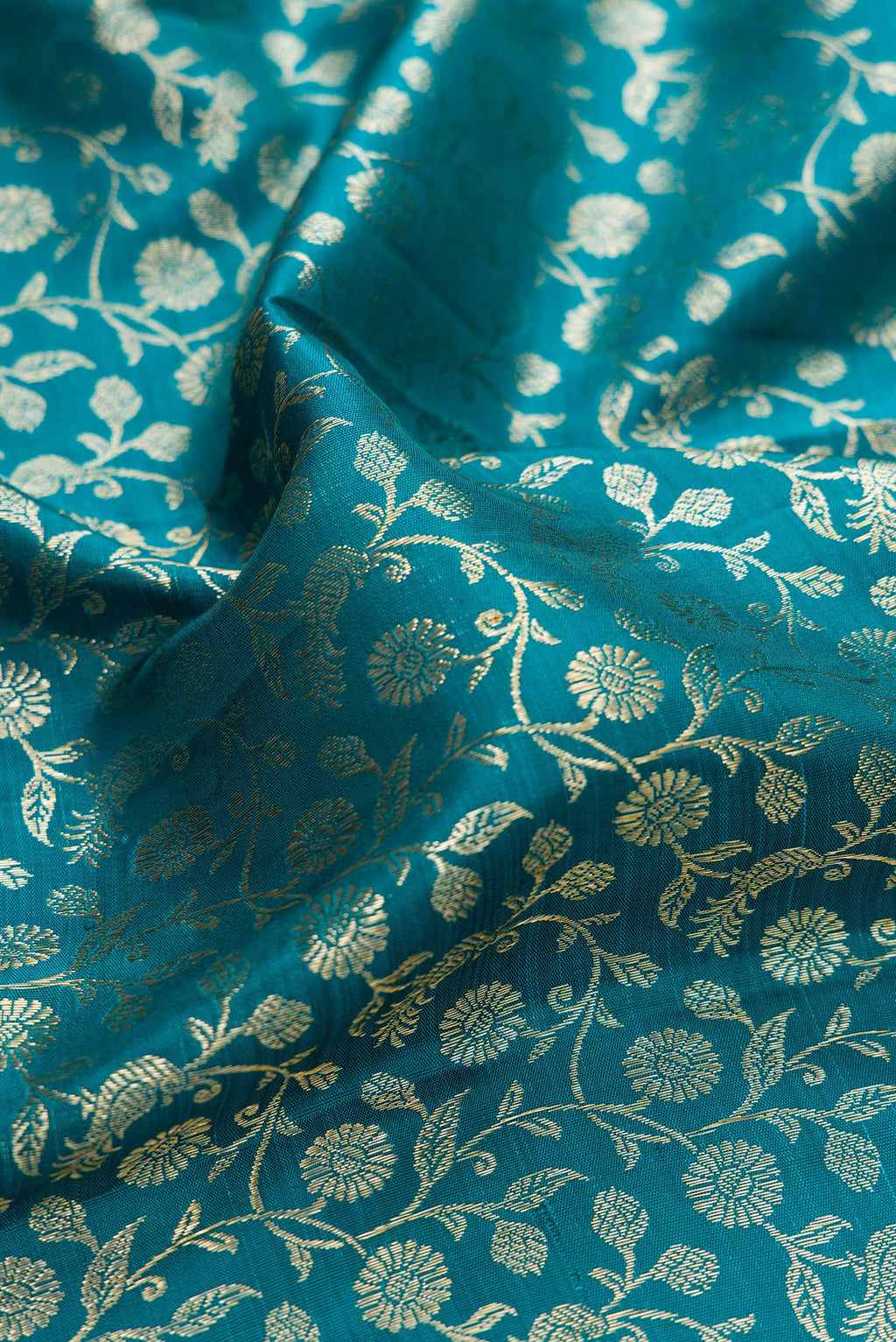 Close up of Teal Kanchipuram Silk Saree with Zari Brocade on the body and Zari Border.  displaying folds