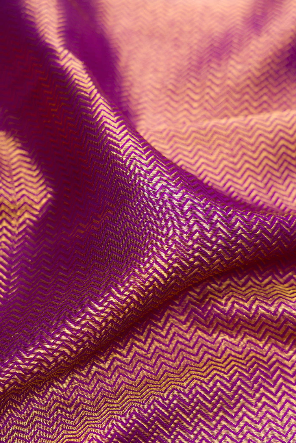 Close up of Purple Kanchipuram Silk Saree with Zari Brocade on the body and Zari Border.  displaying folds