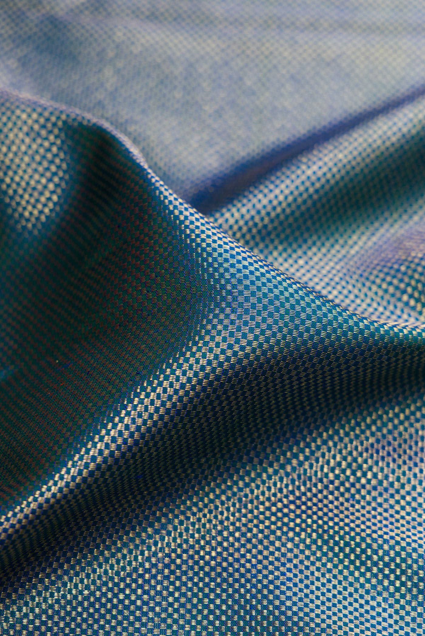 Close up of Peacock Blue Dual Tone Kanchipuram Silk Saree with Zari Brocade on the body and Zari Border.  displaying folds