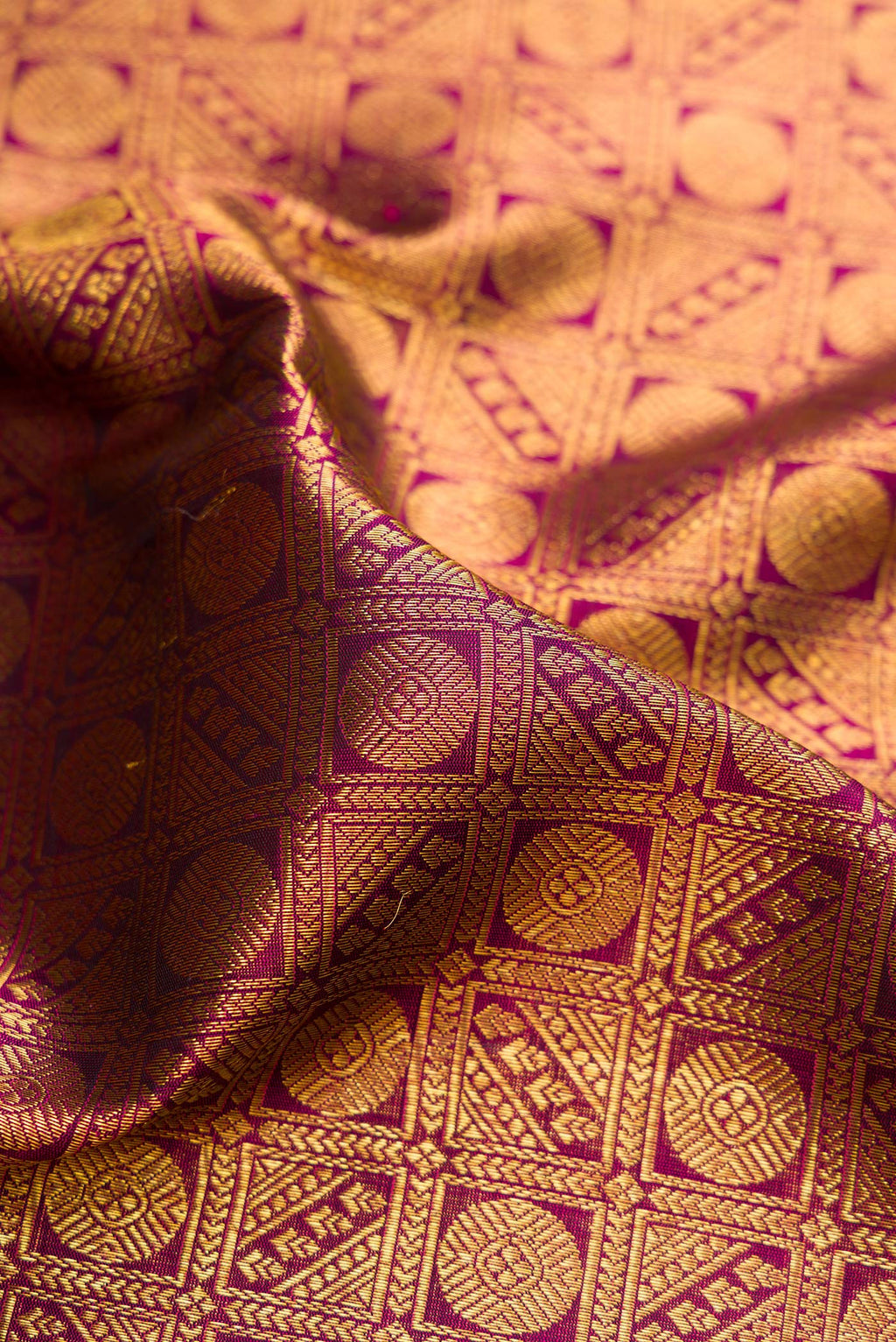 Close up of Magenta Dual Tone Kanchipuram Silk Saree with Zari Brocade on the body and Zari Border.  displaying folds