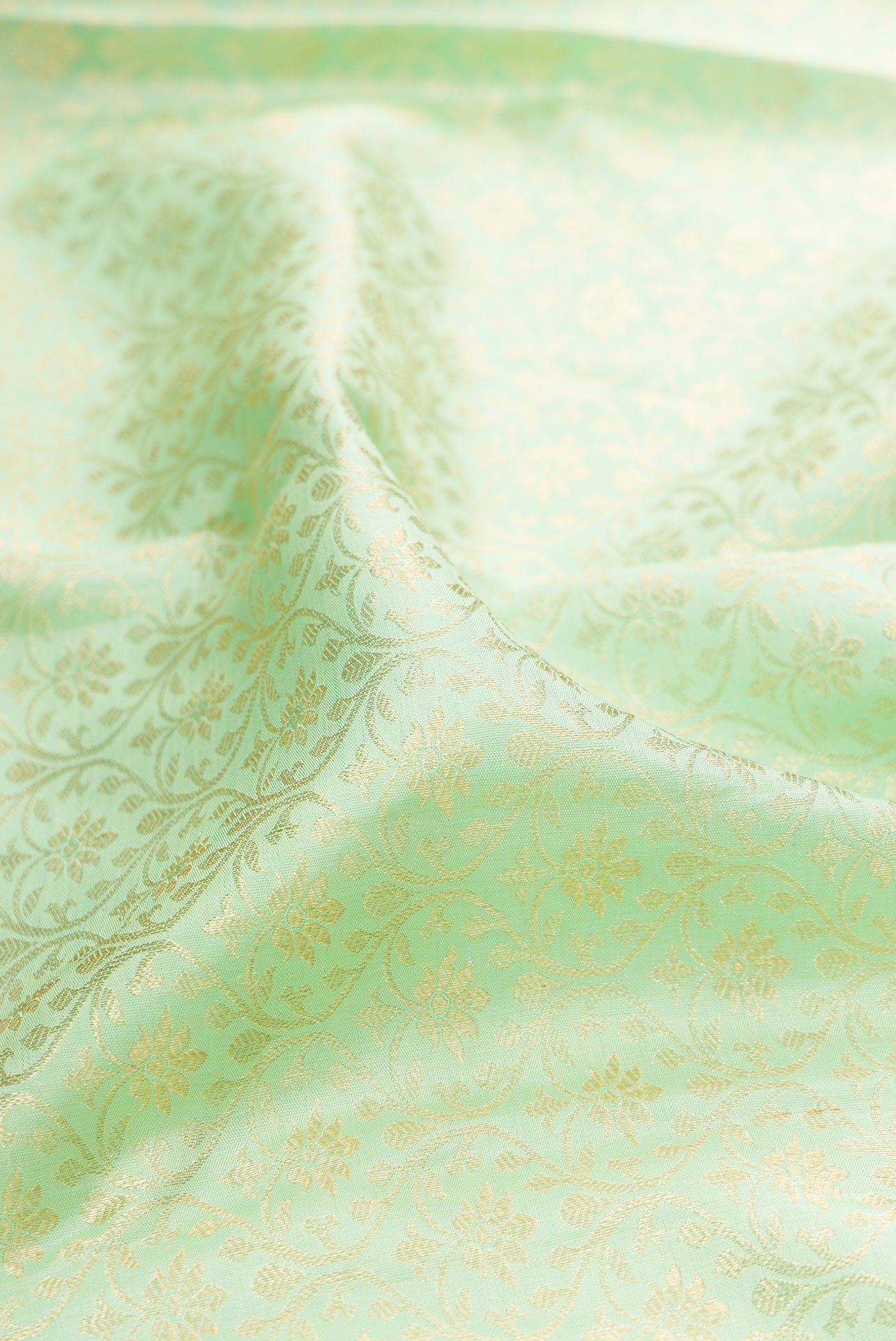 Close up of Pista Green Kanchipuram Silk Saree with Zari Brocade on the body and Zari Border.  displaying folds