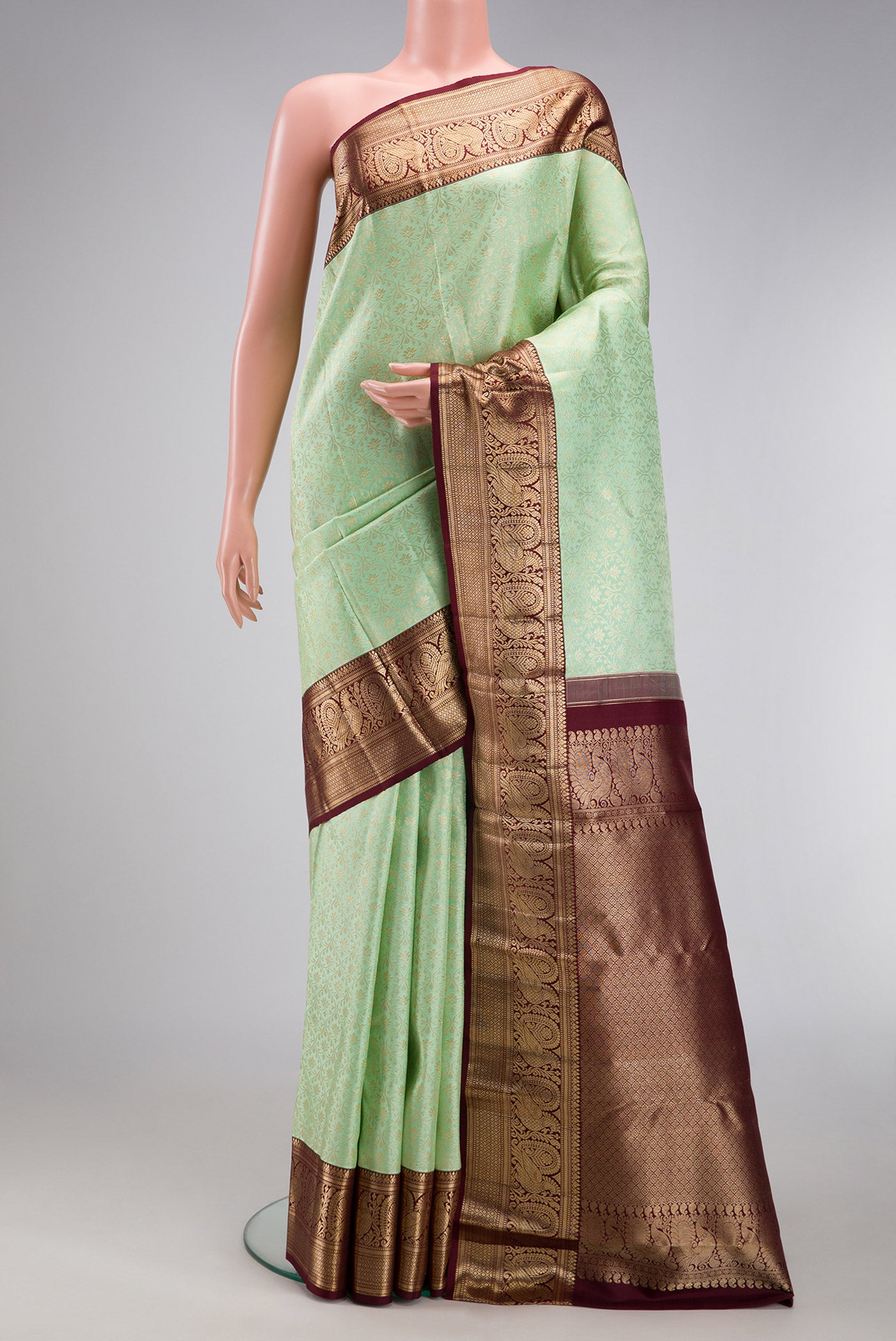 Pista Green Kanchipuram Silk Saree with Zari Brocade on the body and Zari Border.  displayed on a mannequin