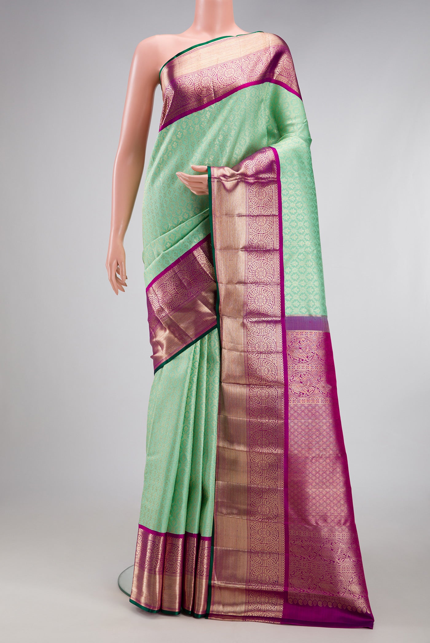 Pista Green Kanchipuram Silk Saree with Zari Brocade on the body and Zari Border.  displayed on a mannequin