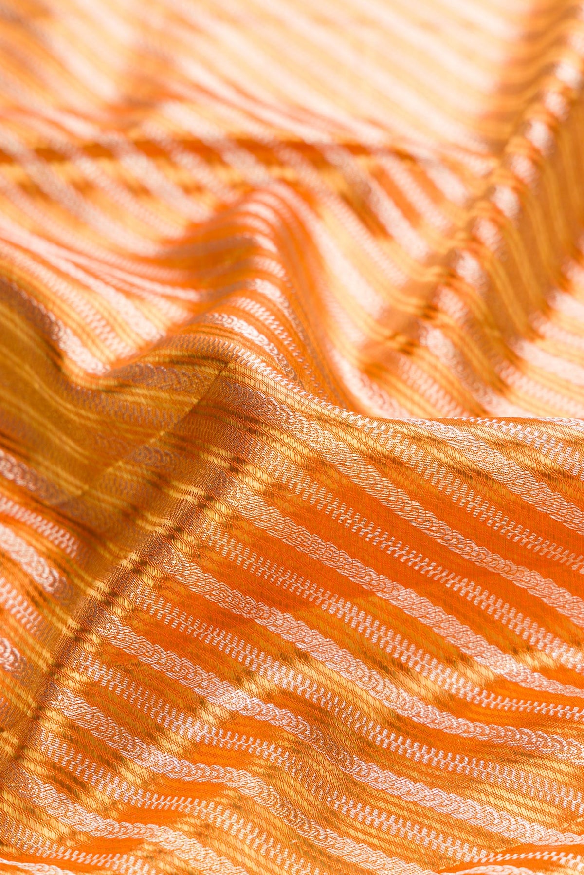 Close up of Orange Dual Tone Kanjivaram Tissue Saree with Zari Brocade on the body and Fancy Border.  displaying folds