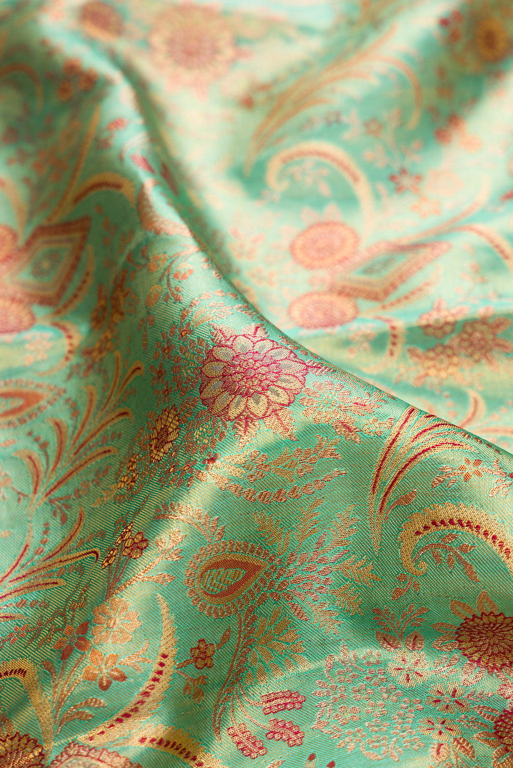 Close up of Sea Green Dual Tone Kanjivaram Tissue Saree with Zari Brocade on the body and Fancy Border.  displaying folds