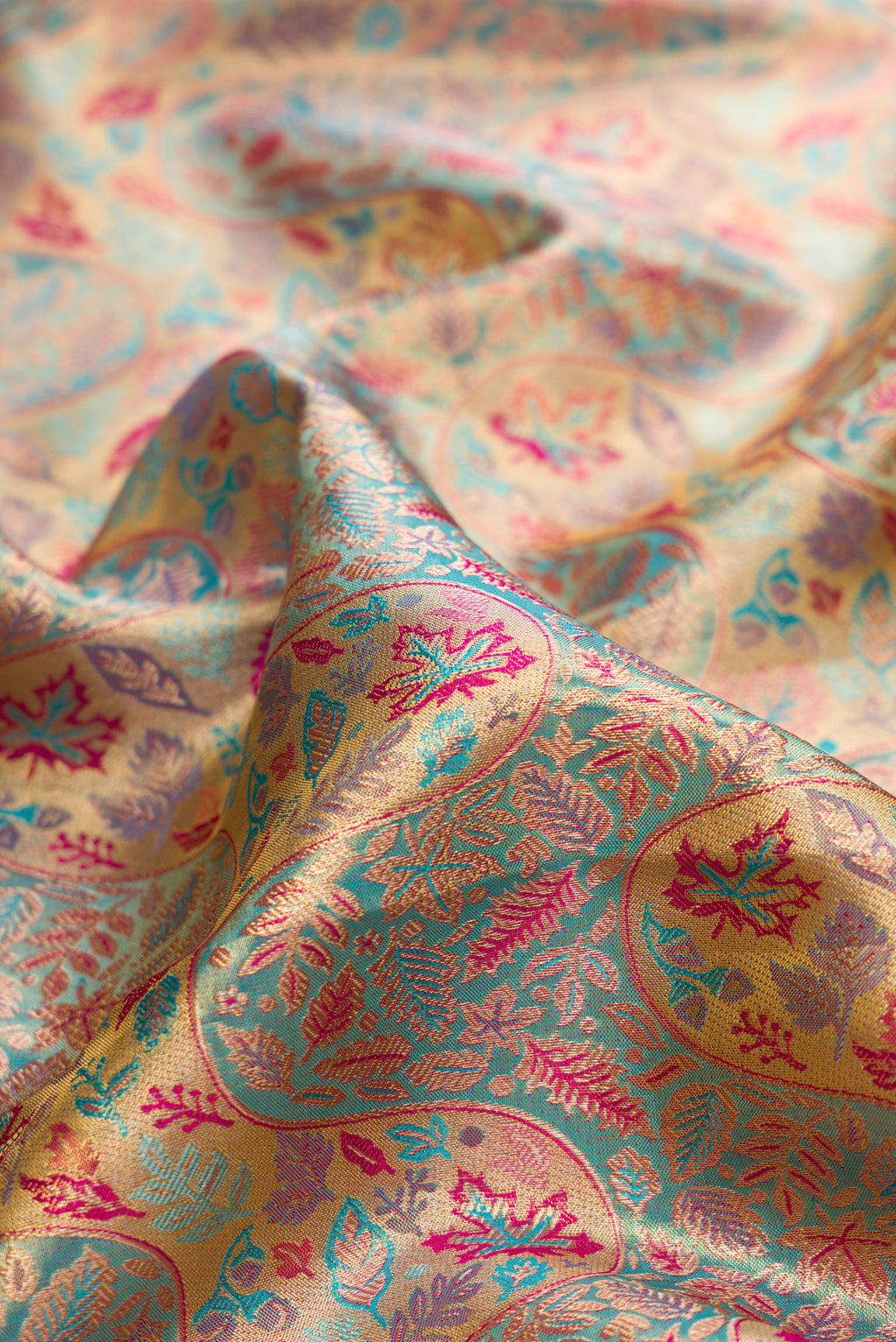 Close up of Turquoise Dual Tone Kanjivaram Tissue Saree with Zari Brocade on the body and Fancy Border.  displaying folds