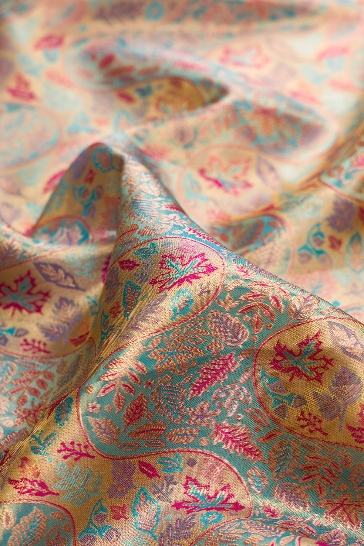 Close up of Turquoise Dual Tone Kanjivaram Tissue Saree with Zari Brocade on the body and Fancy Border.  displaying folds