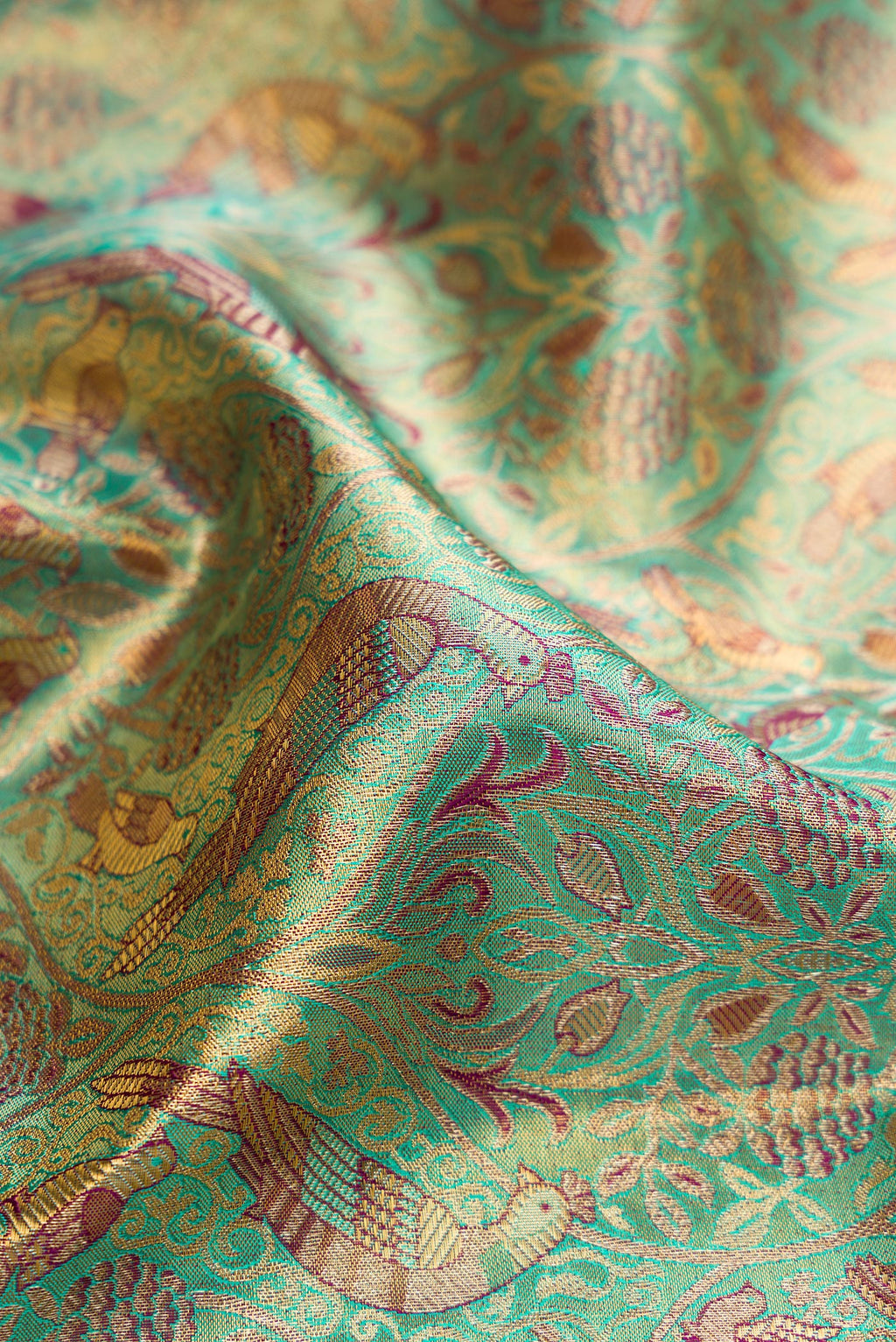 Close up of Sea Green Dual Tone Kanjivaram Tissue Silk Saree with Zari Brocade on the body and Fancy Border.  displaying folds