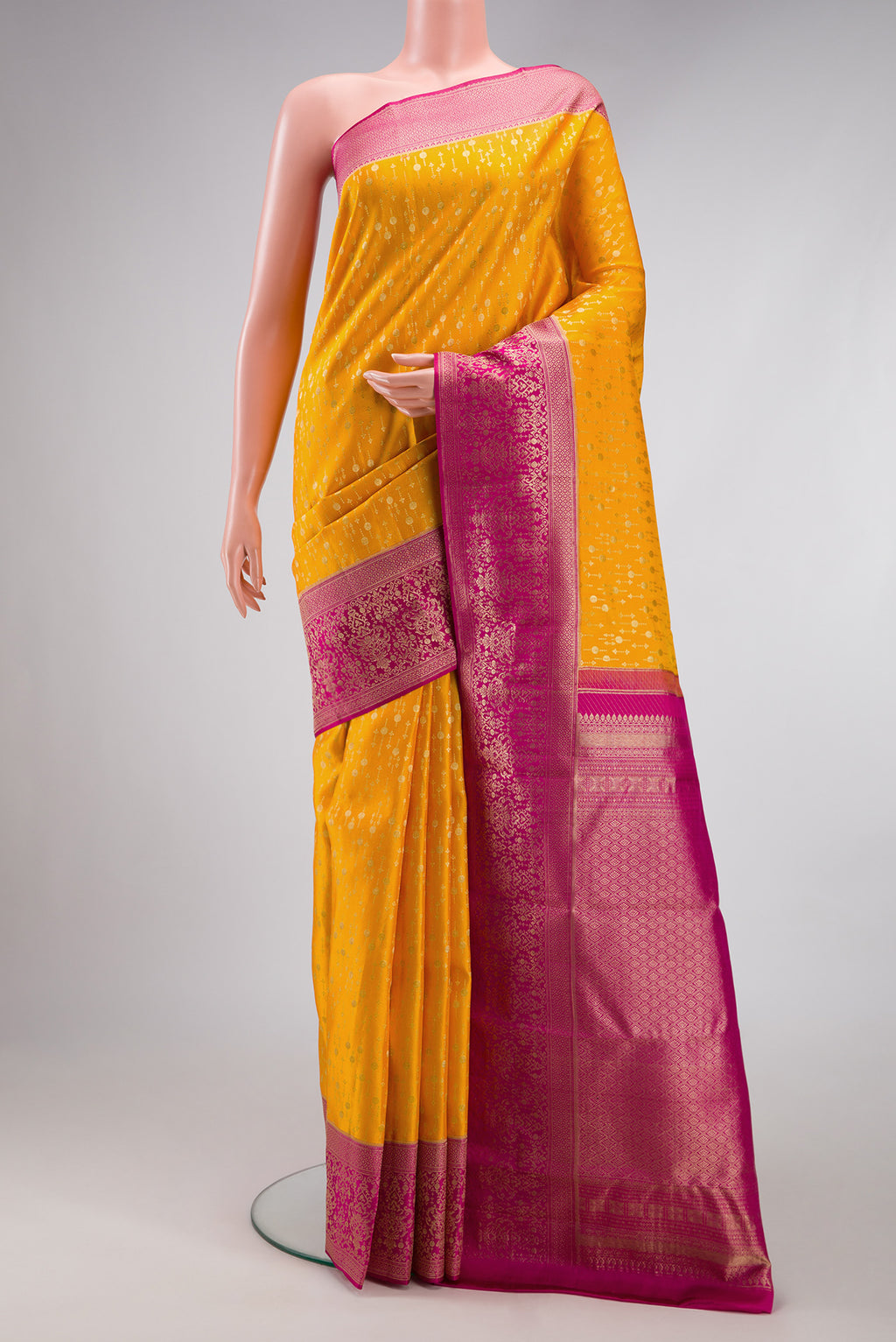 Mustard Kanchipuram Silk Saree with Zari Brocade on the body and Fancy Border.  displayed on a mannequin