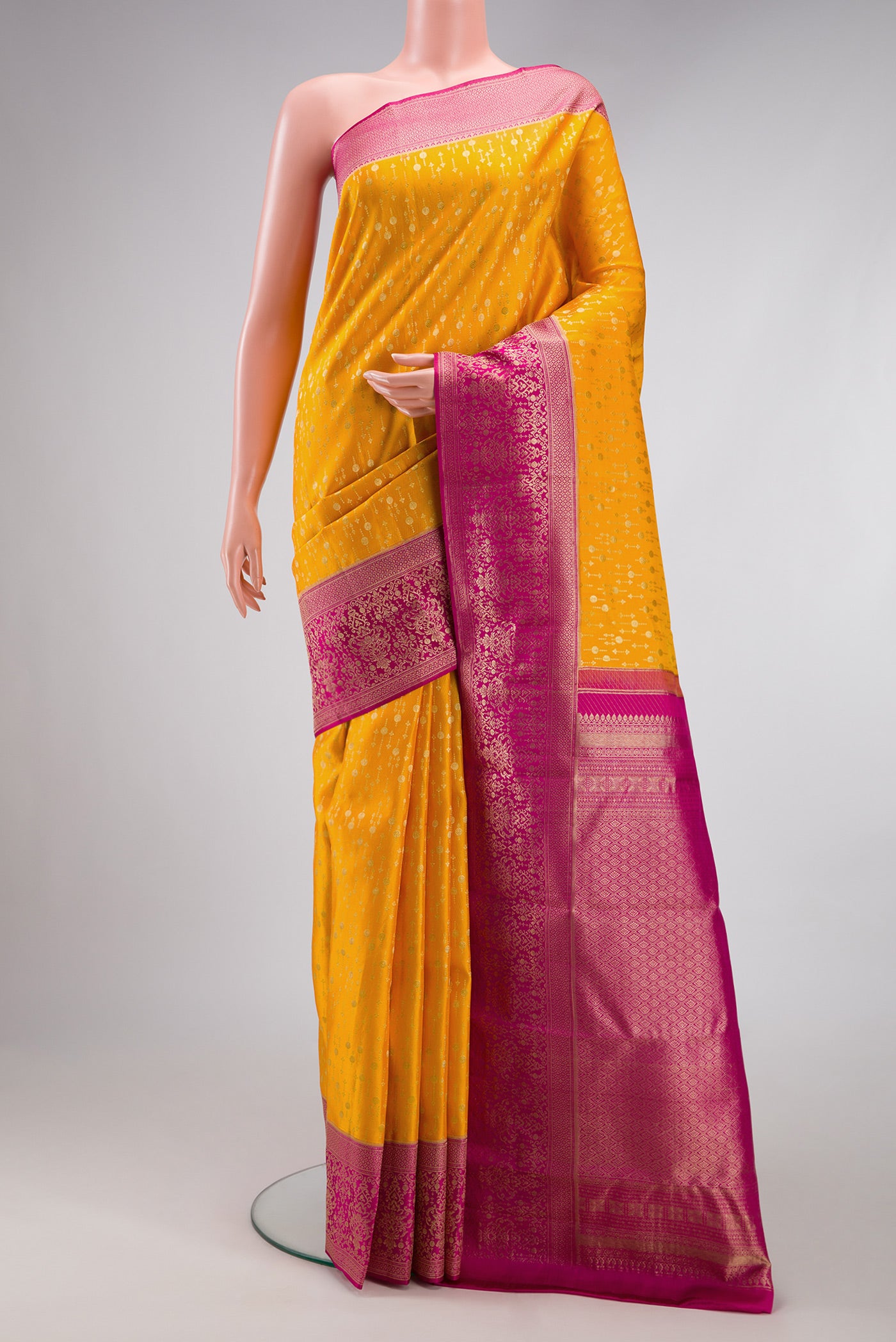 Mustard Kanchipuram Silk Saree with Zari Brocade on the body and Fancy Border.  displayed on a mannequin