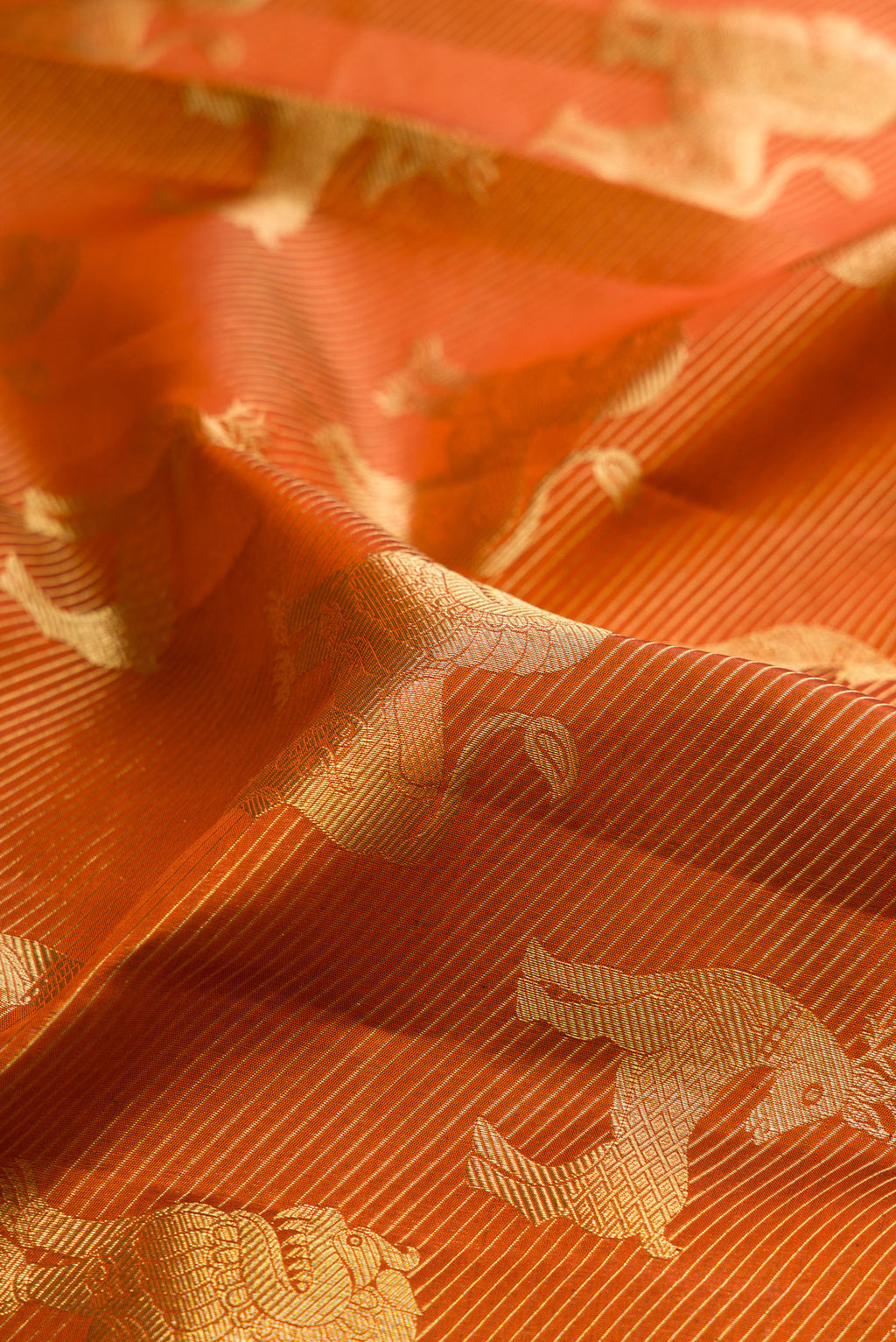 Close up of Rust Kanchipuram Silk Saree with Zari Brocade on the body and Without Border.  displaying folds