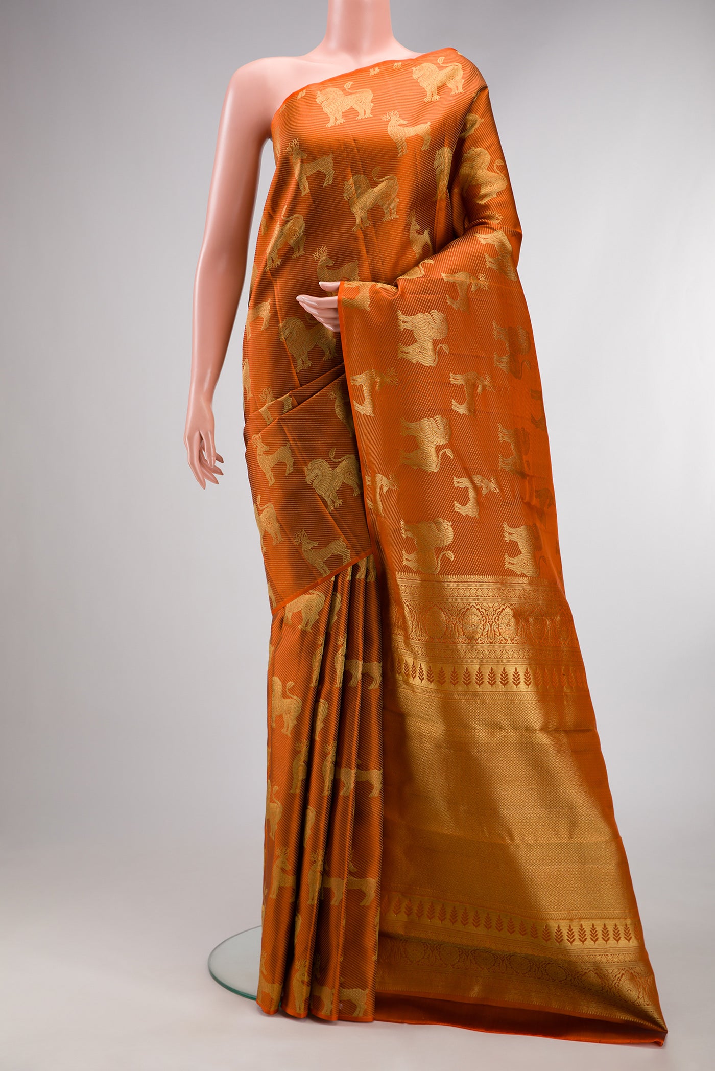 Rust Kanchipuram Silk Saree with Zari Brocade on the body and Without Border.  displayed on a mannequin