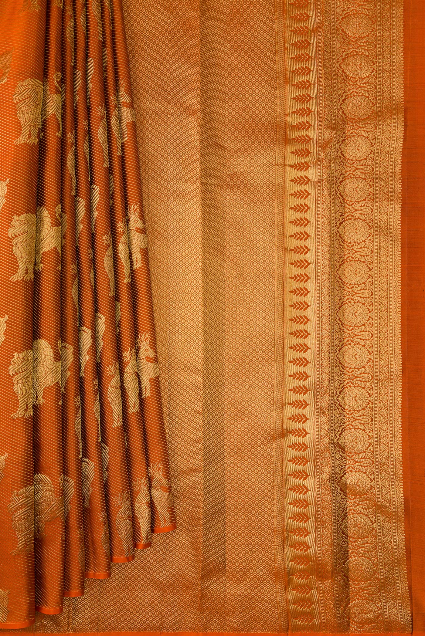 Pleats and pallu of Rust Kanchipuram Silk Saree with Zari Brocade on the body and Without Border. 
