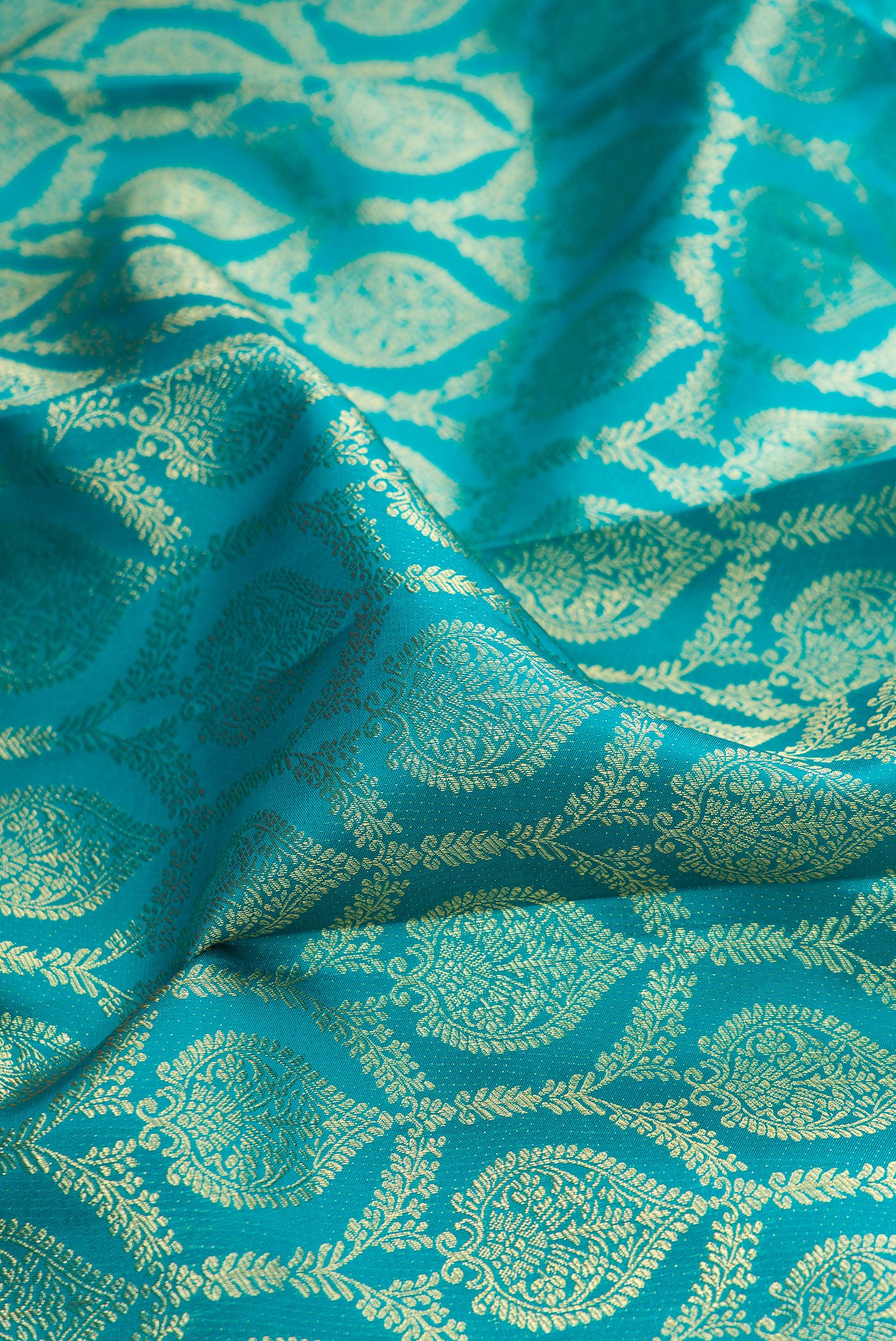 Close up of Green Dual Tone Kanjivaram Silk Saree with Zari Brocade on the body and Zari Border.  displaying folds