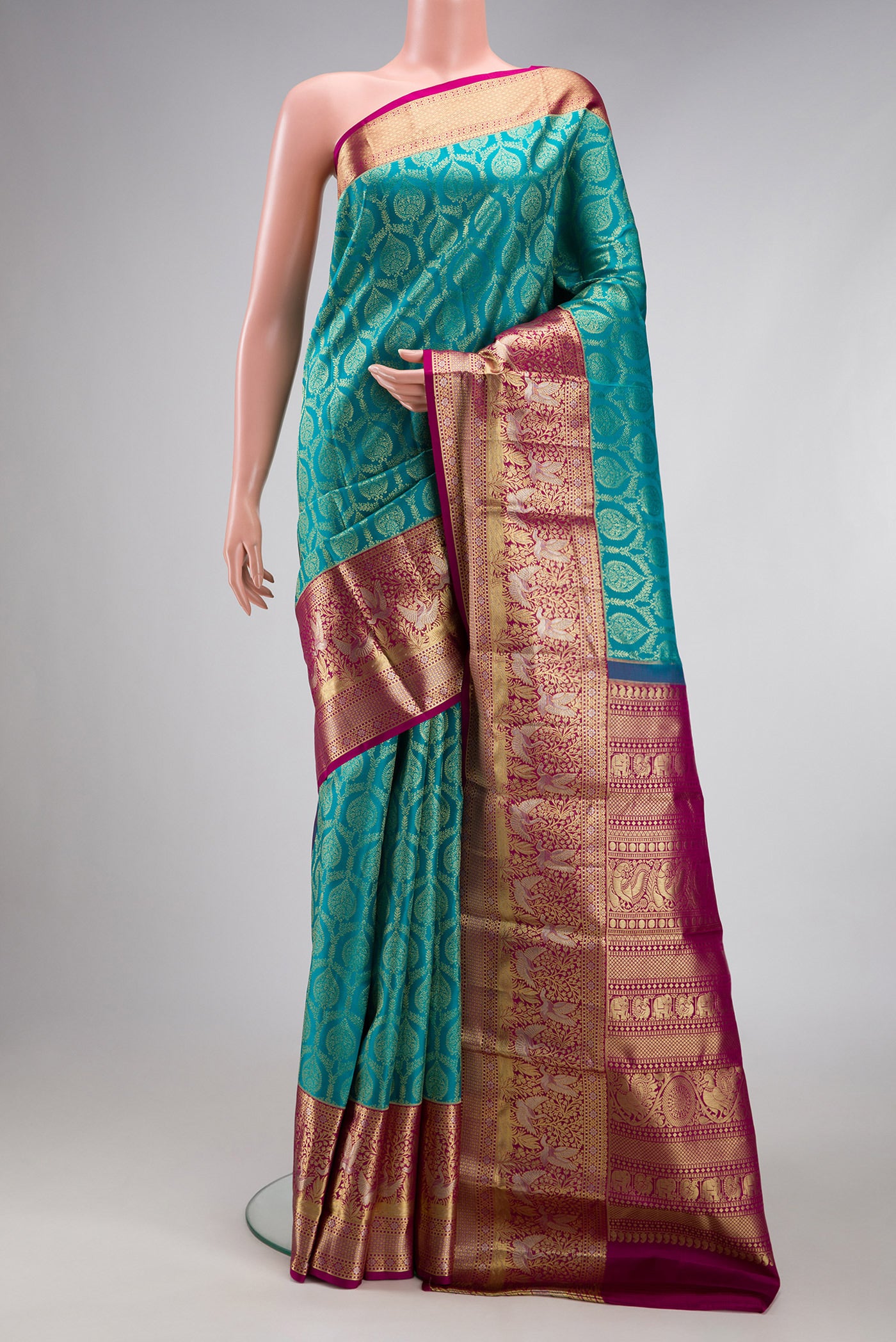 Green Dual Tone Kanjivaram Silk Saree with Zari Brocade on the body and Zari Border.  displayed on a mannequin