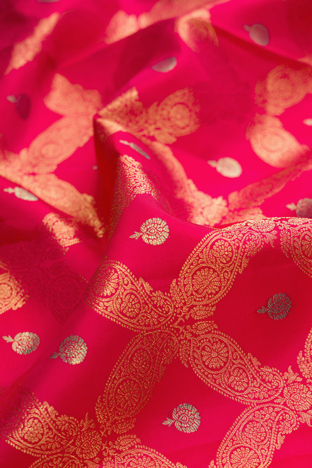 Close up of Pure Silk Dark Pink Dual Tone Kanjivaram Saree with Zari Brocade on the body and Zari Border.  displaying folds
