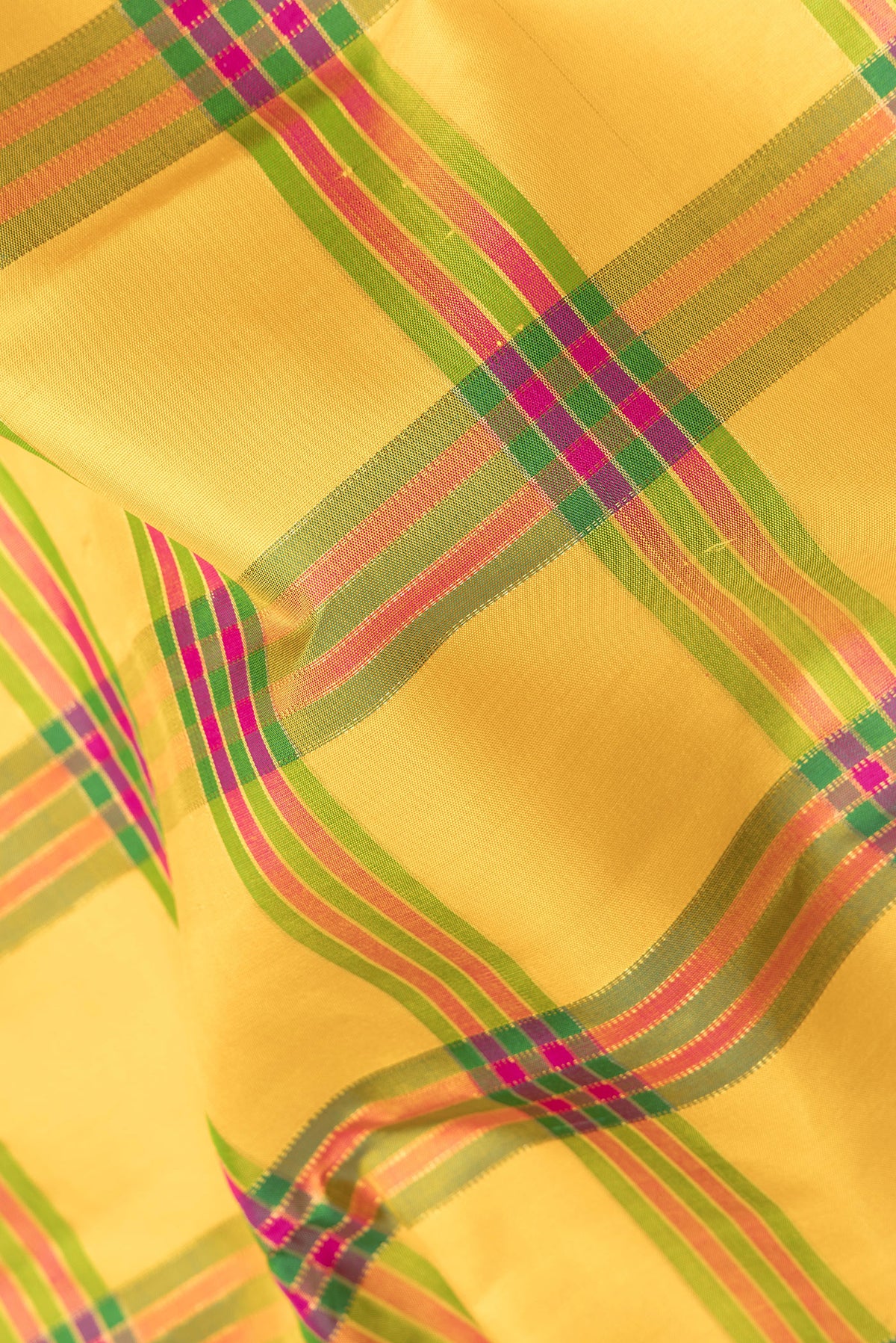 Close up of Pure Silk Yellow Kanjivaram Saree with Checked design on the body and Fancy Border.  displaying folds