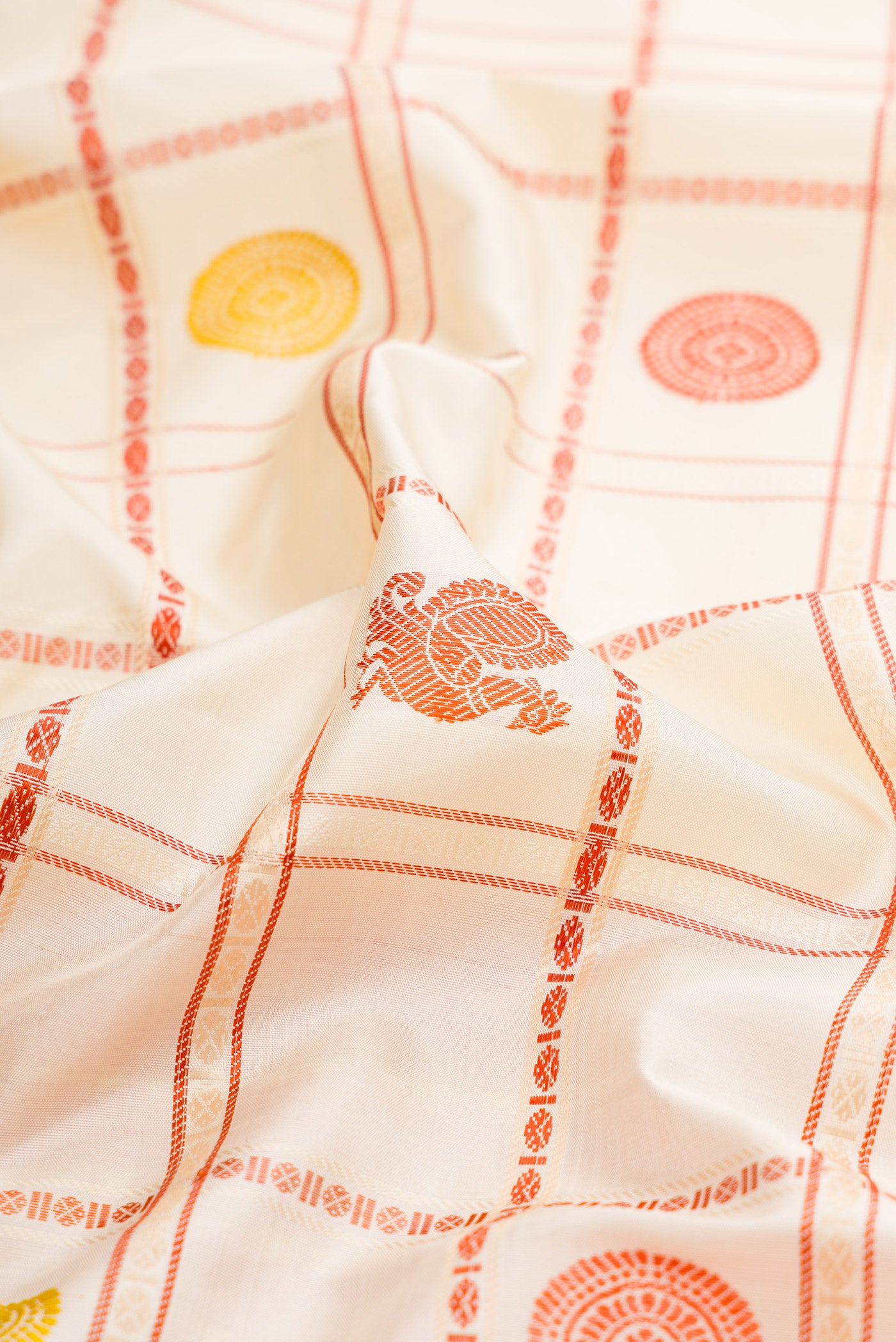 Close up of Cream Kanchipuram Silk Saree with Checked design on the body and Thread Border.  displaying folds