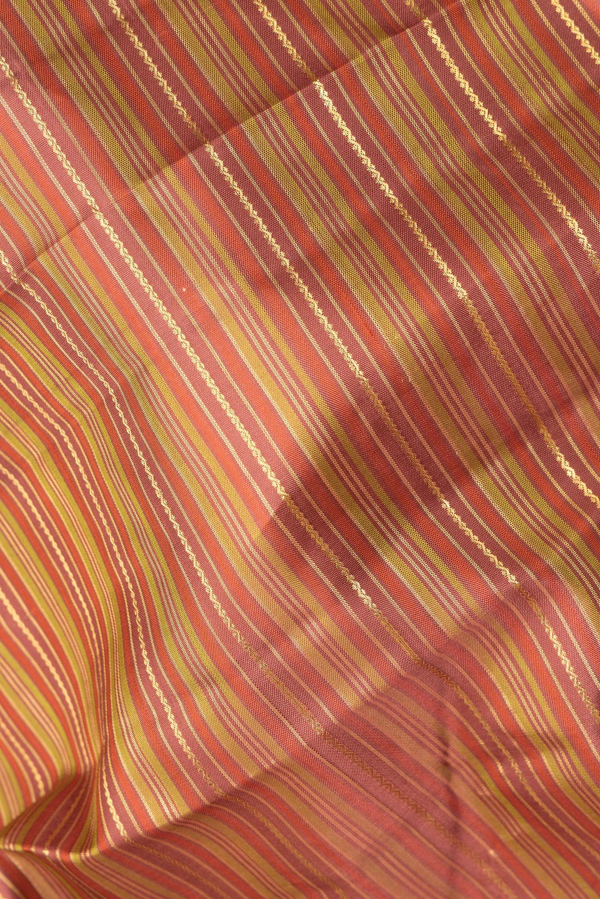 Close up of Pure Silk Rust and Green Color Kanchipuram Saree with Stripes on the body and Zari Border.  displaying folds