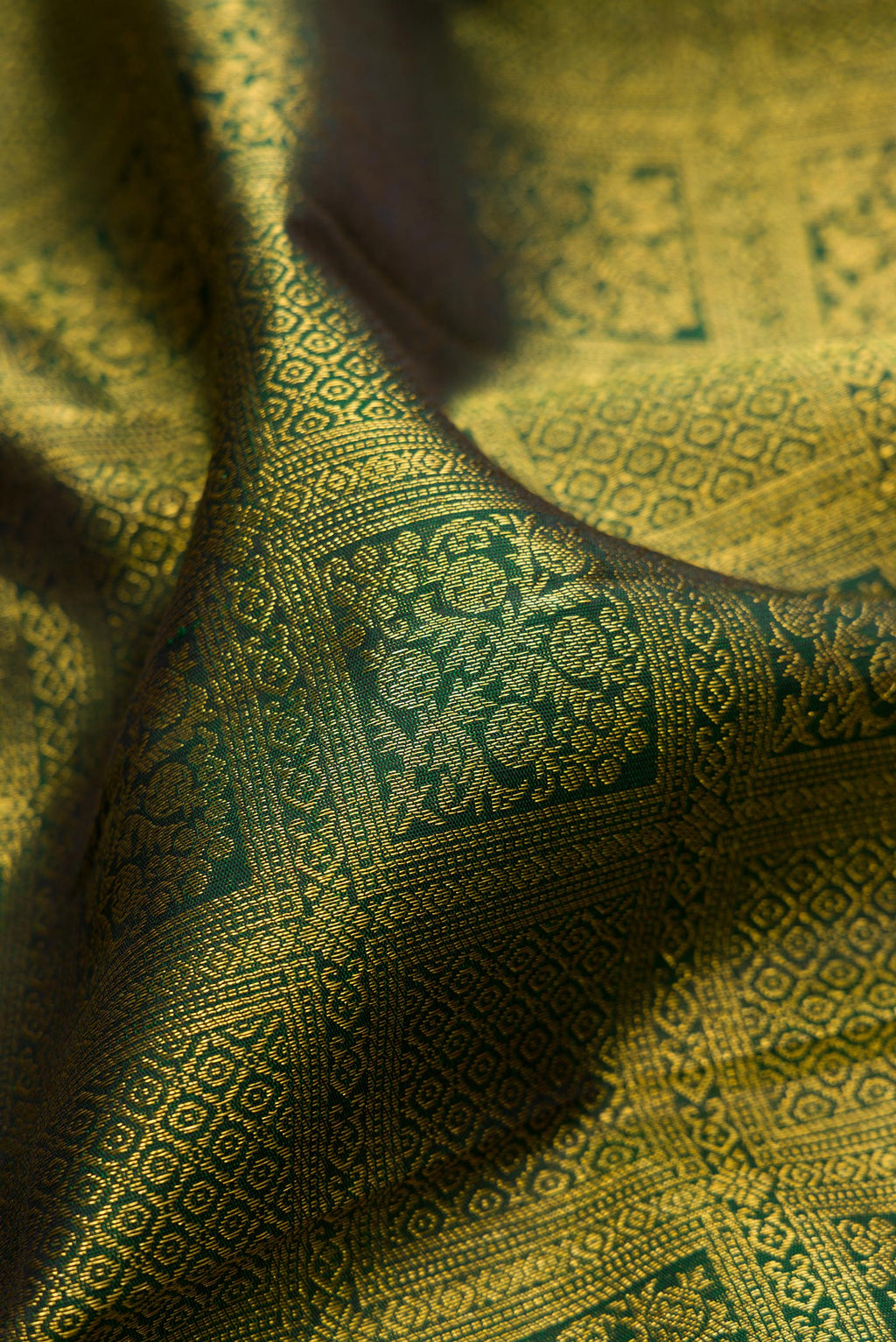 Close up of Bottle Green Kanchipuram Silk Saree with Zari Brocade on the body and Fancy Border.  displaying folds