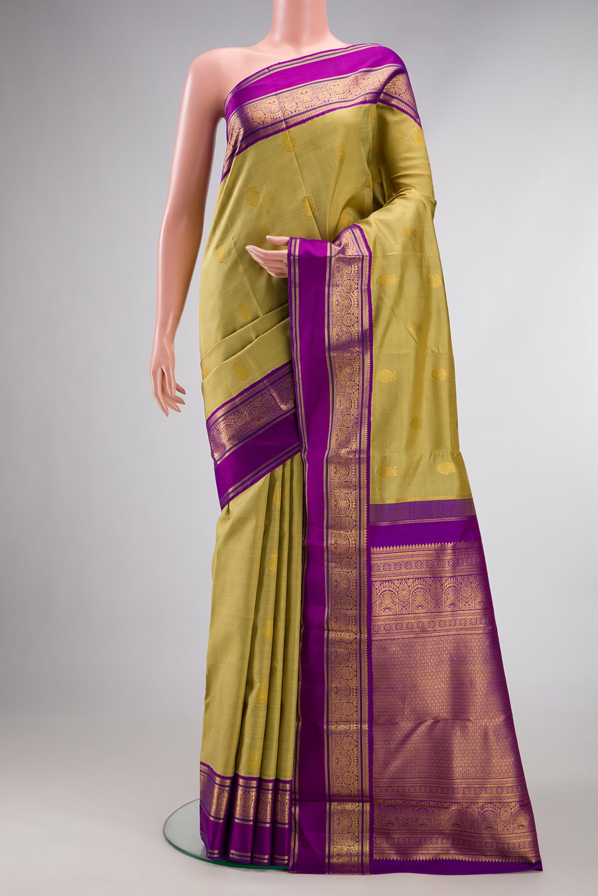 Pure Silk Gold Kanchipuram Saree with Zari Butta on the body and Zari Border.  displayed on a mannequin